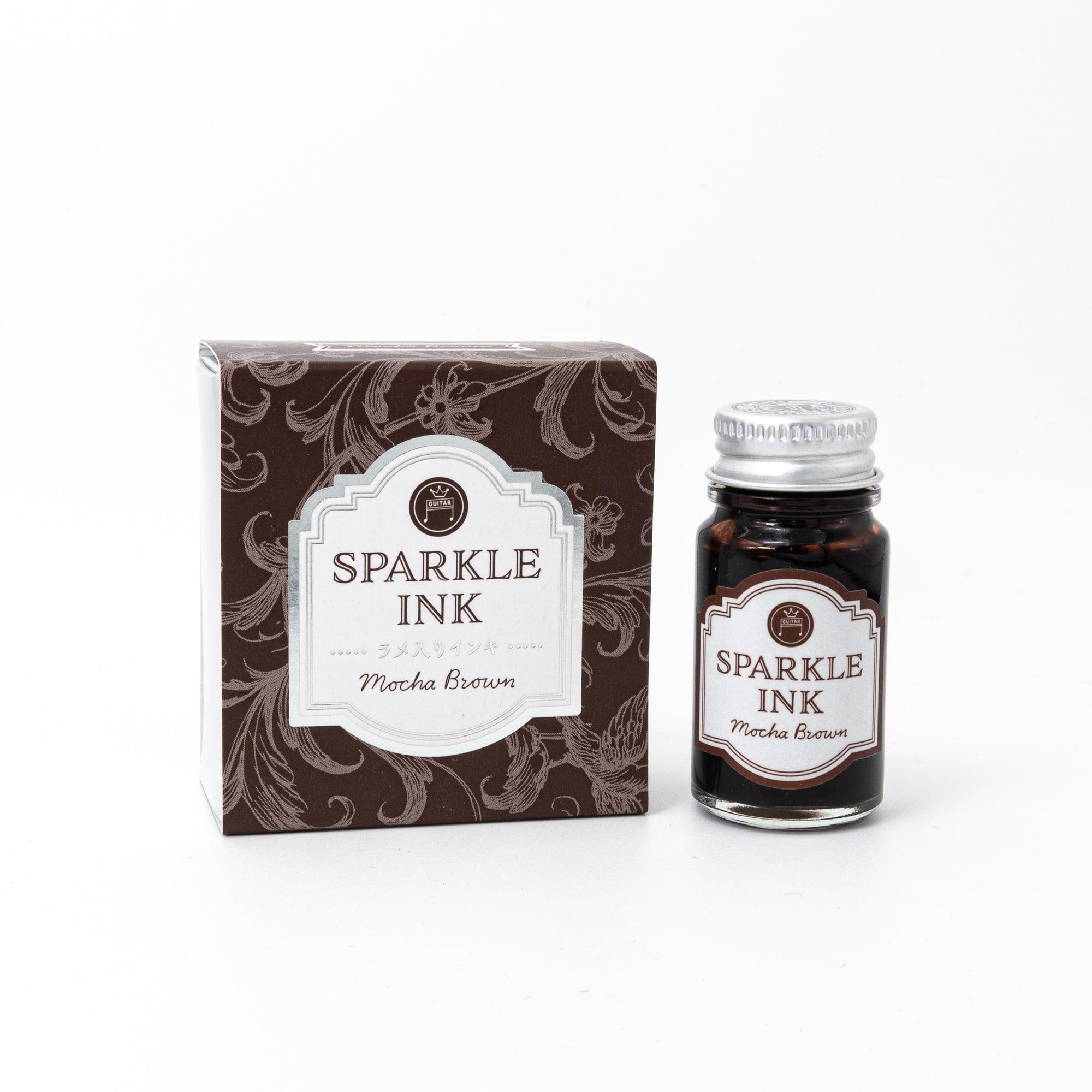 Sparkle Ink in Mocha Brown, presented in a glass bottle with elegant packaging adorned with floral patterns in rich brown tones.