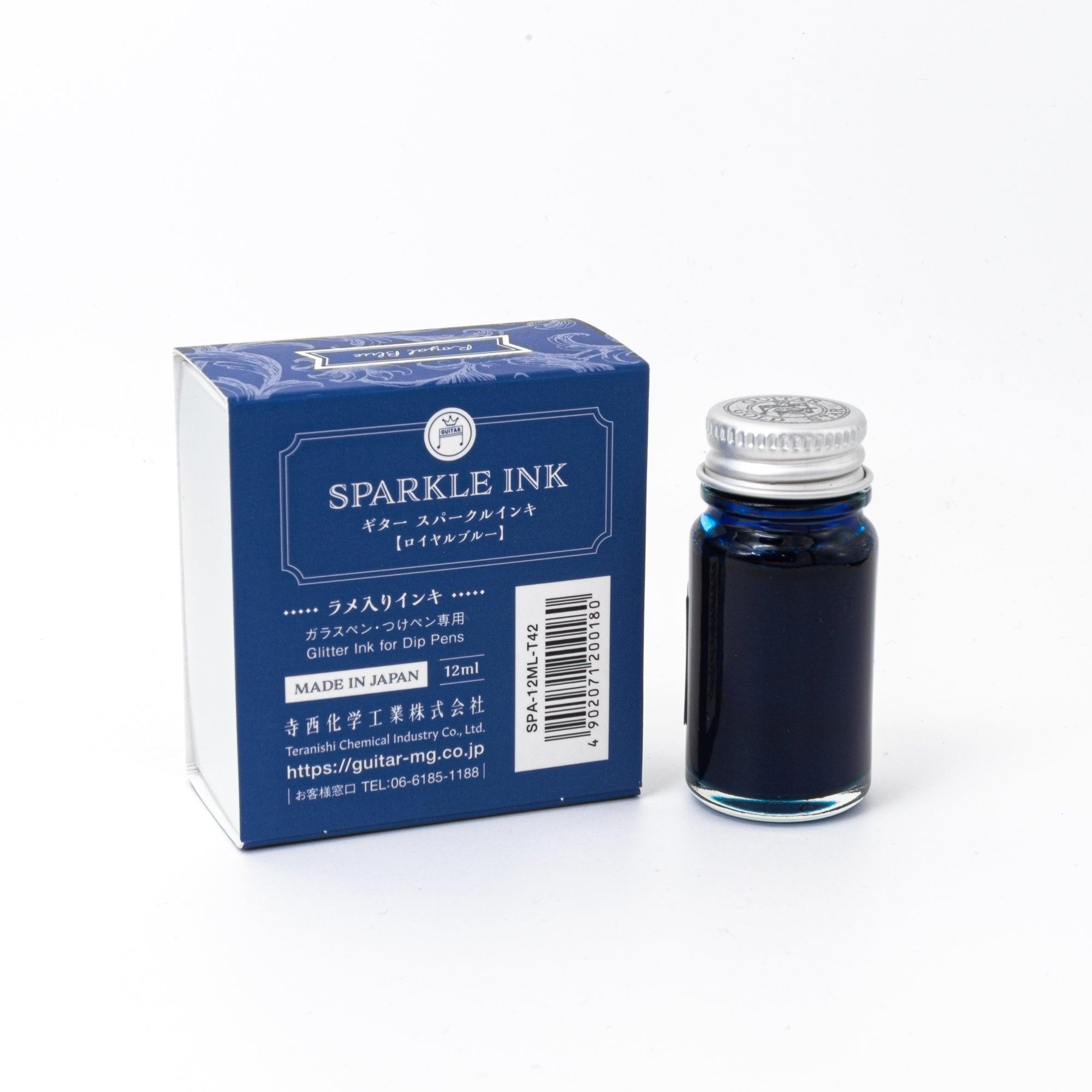 Sparkle Ink in Royal Blue, displayed in a glass bottle with elegant packaging featuring floral patterns in matching blue tones.