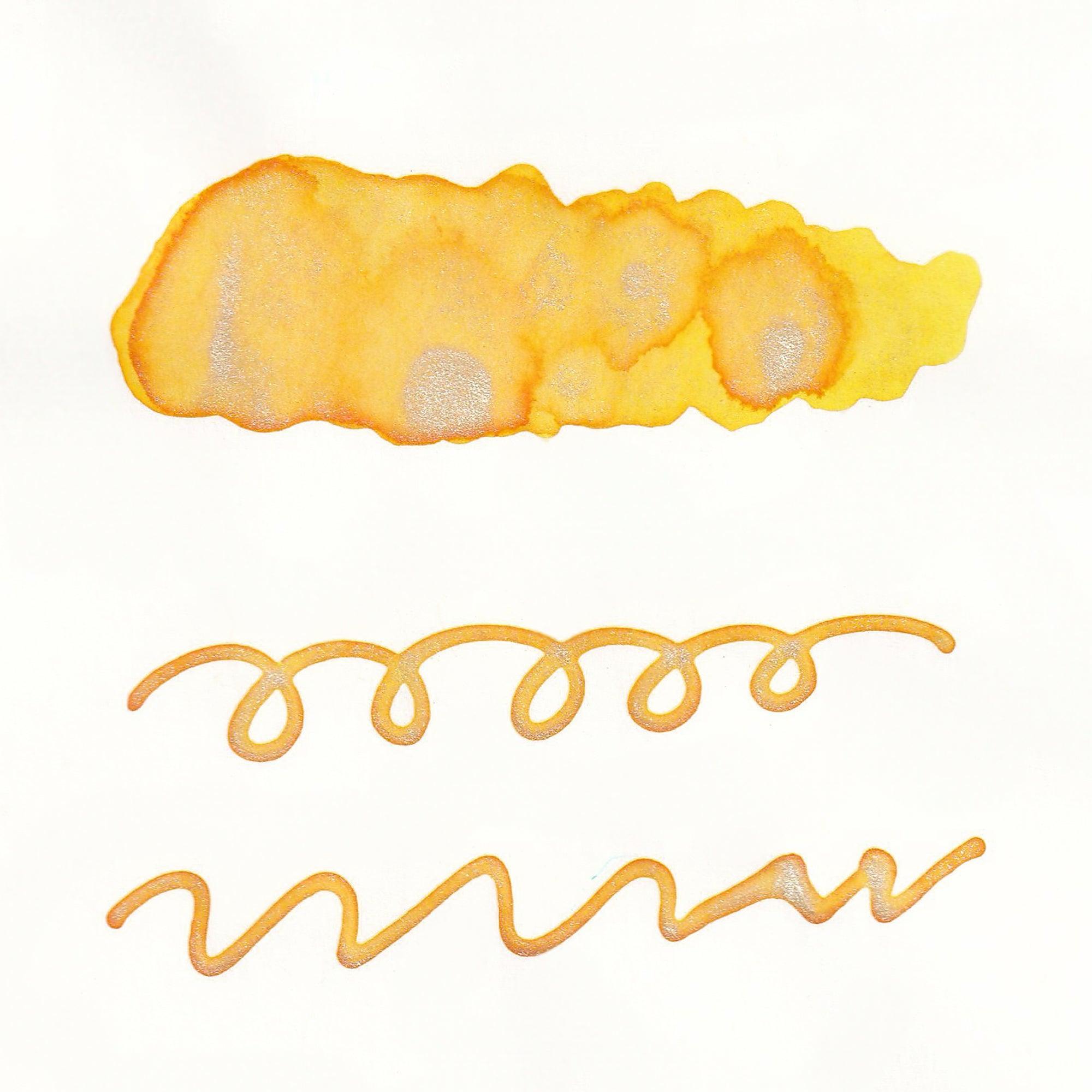 Swatches of Sparkle Ink in Sunny Yellow, featuring vibrant yellow tones with shimmering accents, displayed as lines and a solid stroke on white paper.