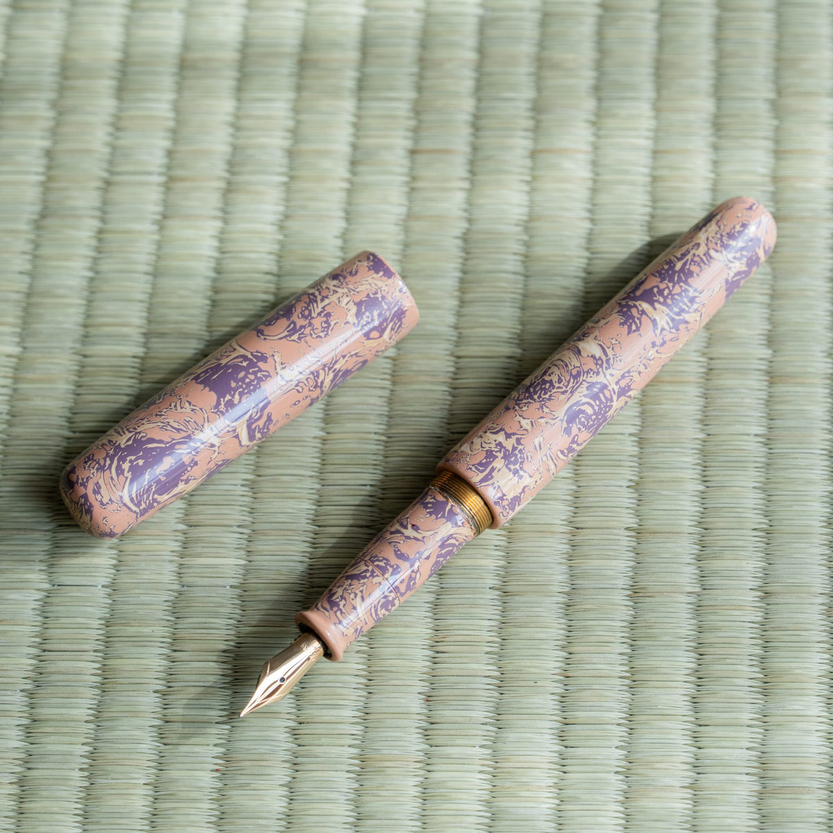 Hanagasumi Tsugaru-nuri fountain pen uncapped beside its cap, gold-colored nib, brass threads and pink barrel