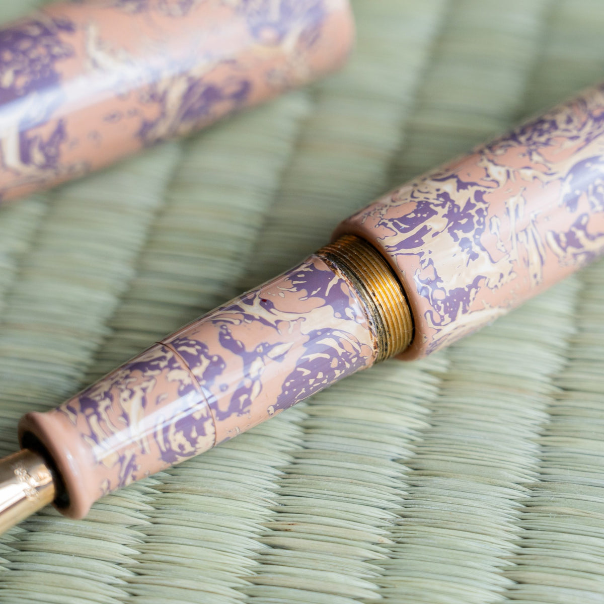 Close-up of the Hanagasumi section and brass threads, pink and purple urushi lacquer