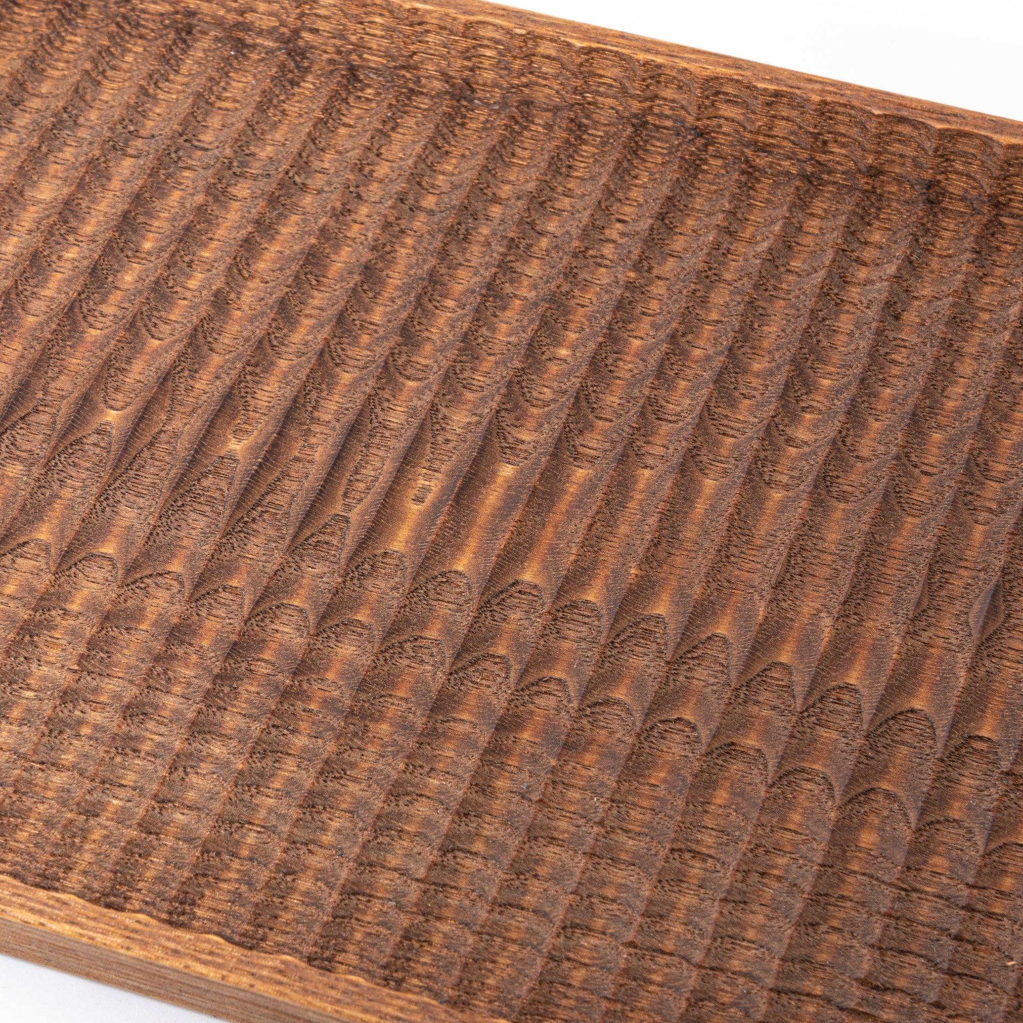 Wagatabon tray angled view showing carved texture, light wood finish, and pen placement slots with clear visibility of