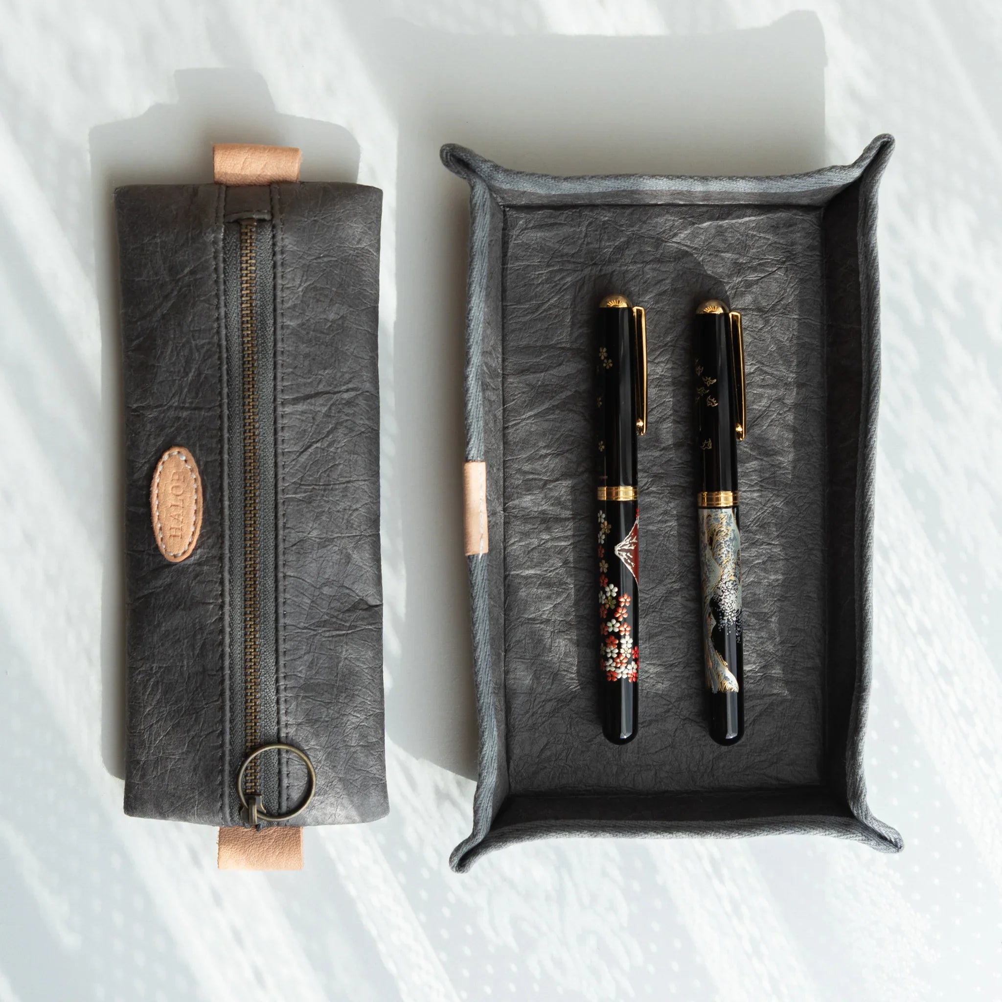 Grey Japanese Pen Case made of Sugihara Washi displayed with two Japanese Fountain Pens in matching purple tray.