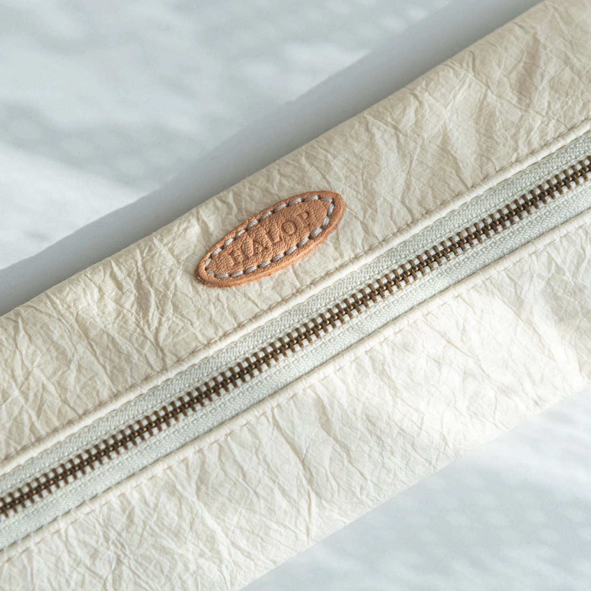 Close-up of the leather “HALOP” tag stitched on the purple Sugihara Washi Japanese Pen Case.