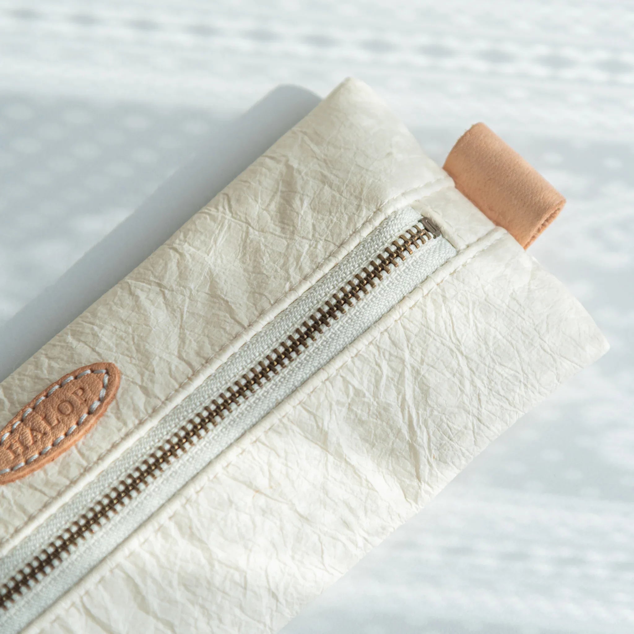 Detailed view of the right end of the Japanese Pen Case, highlighting the beige leather pull and textured white washi surface.