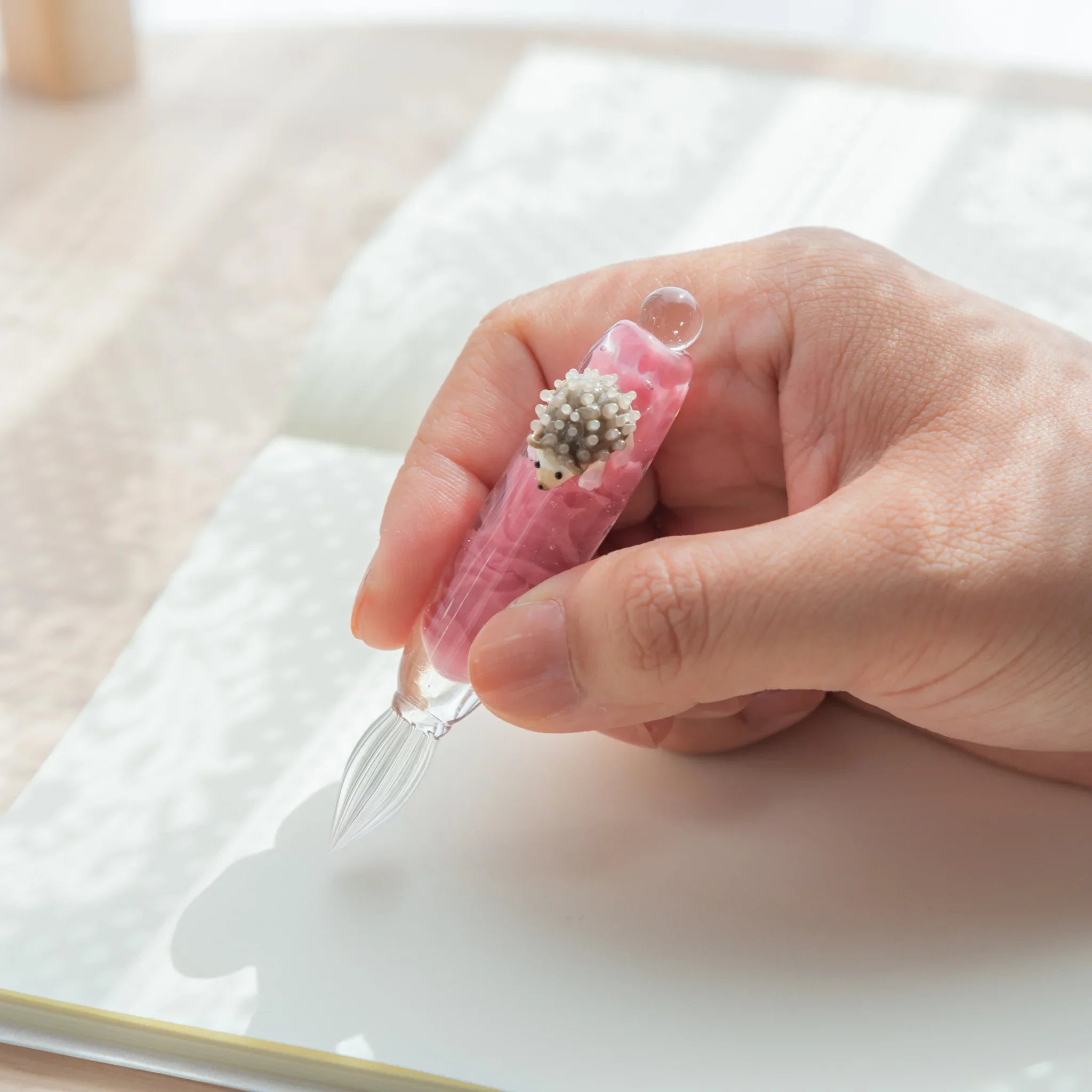hand-made hedgehog glass dip pen featuring charming woodland animal on glass barrel base with wooden stand