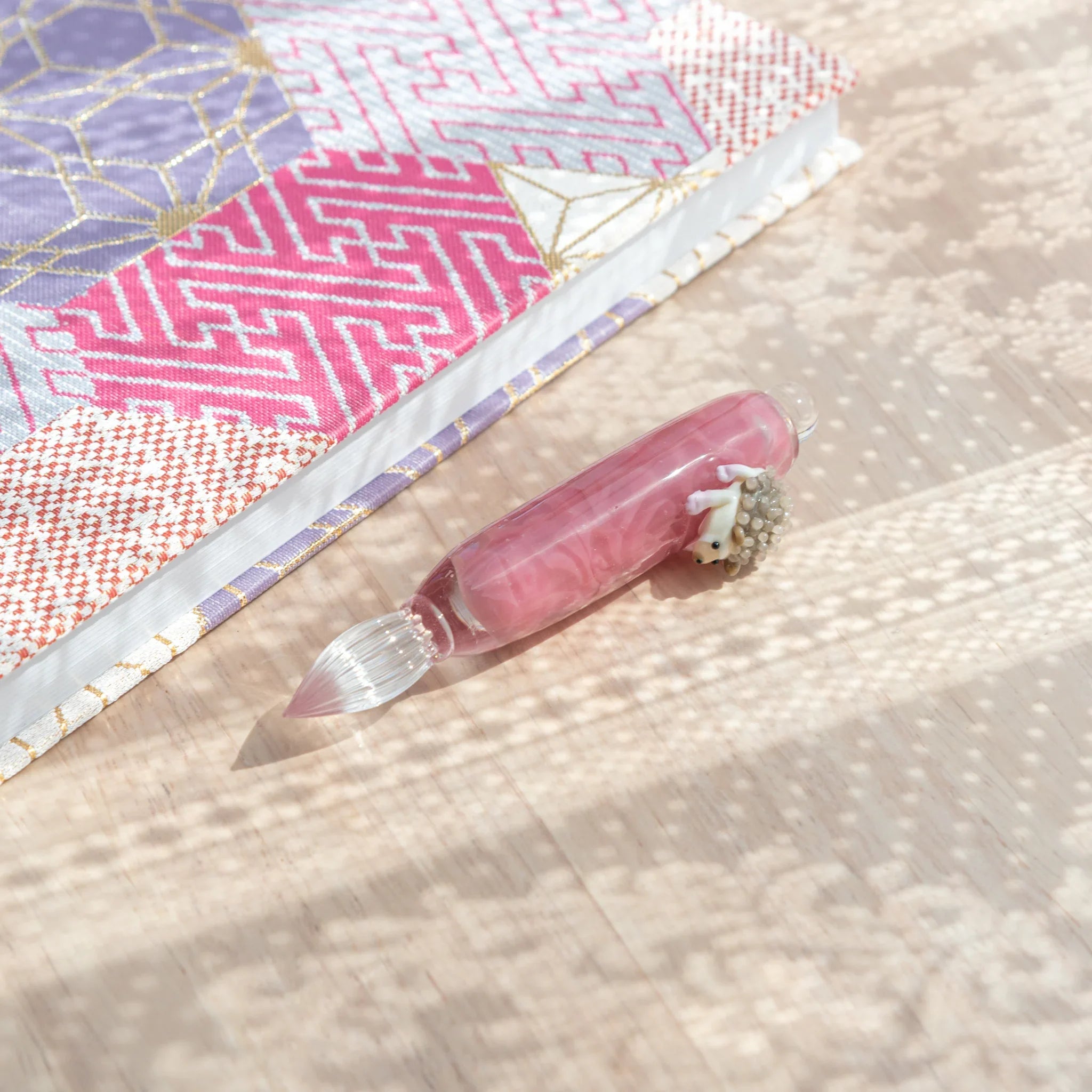 Unique hedgehog glass dip pen combining detailed resin creature with hand-poured glass barrel design