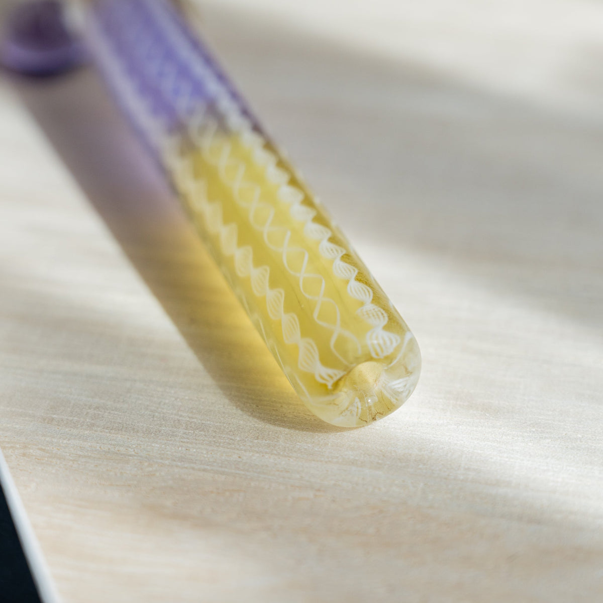 Detail of the Helix Wisteria glass canes twisting from lavender into yellow along the pen barrel