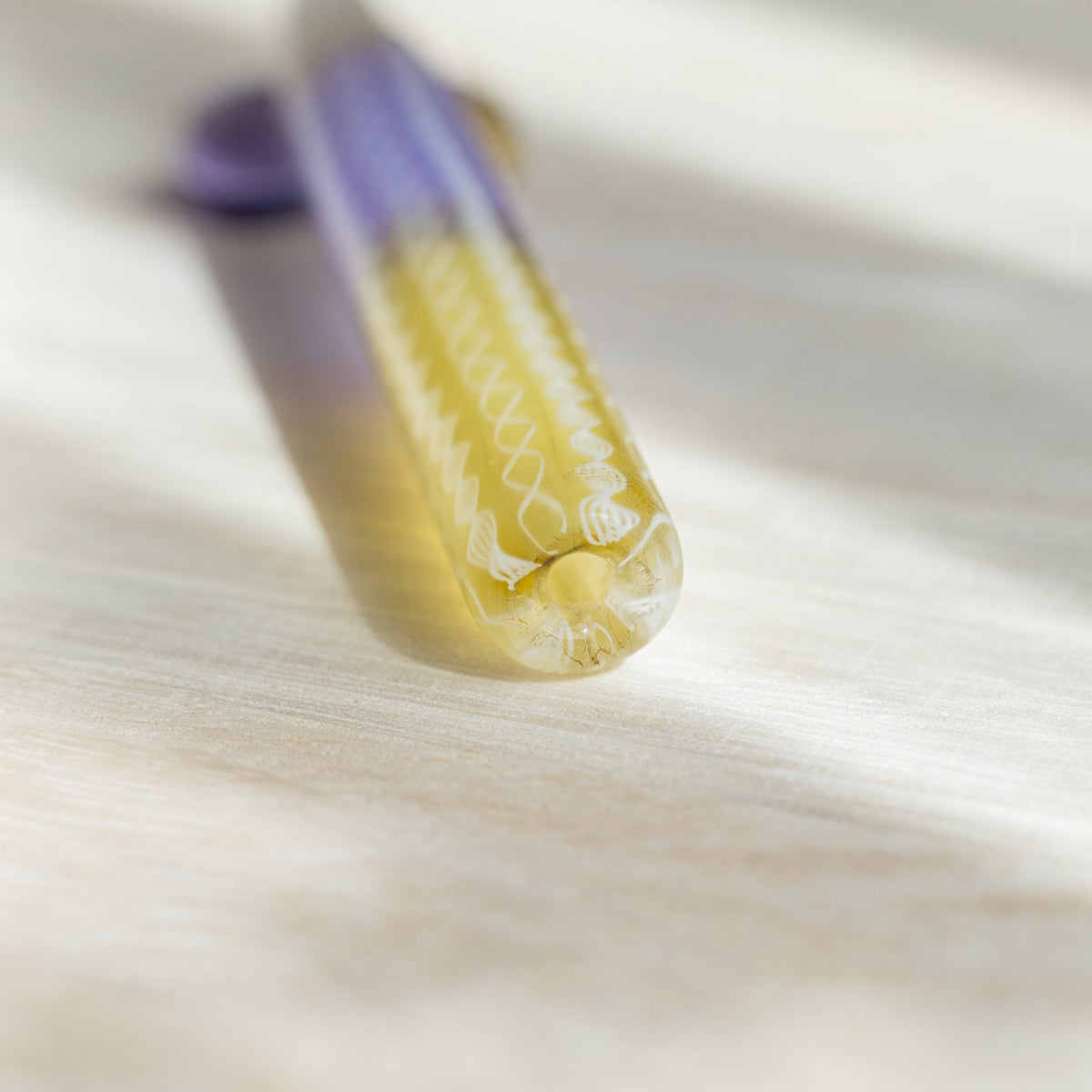 Close-up of the rounded yellow end of the Helix Wisteria barrel with white spiral lace canes