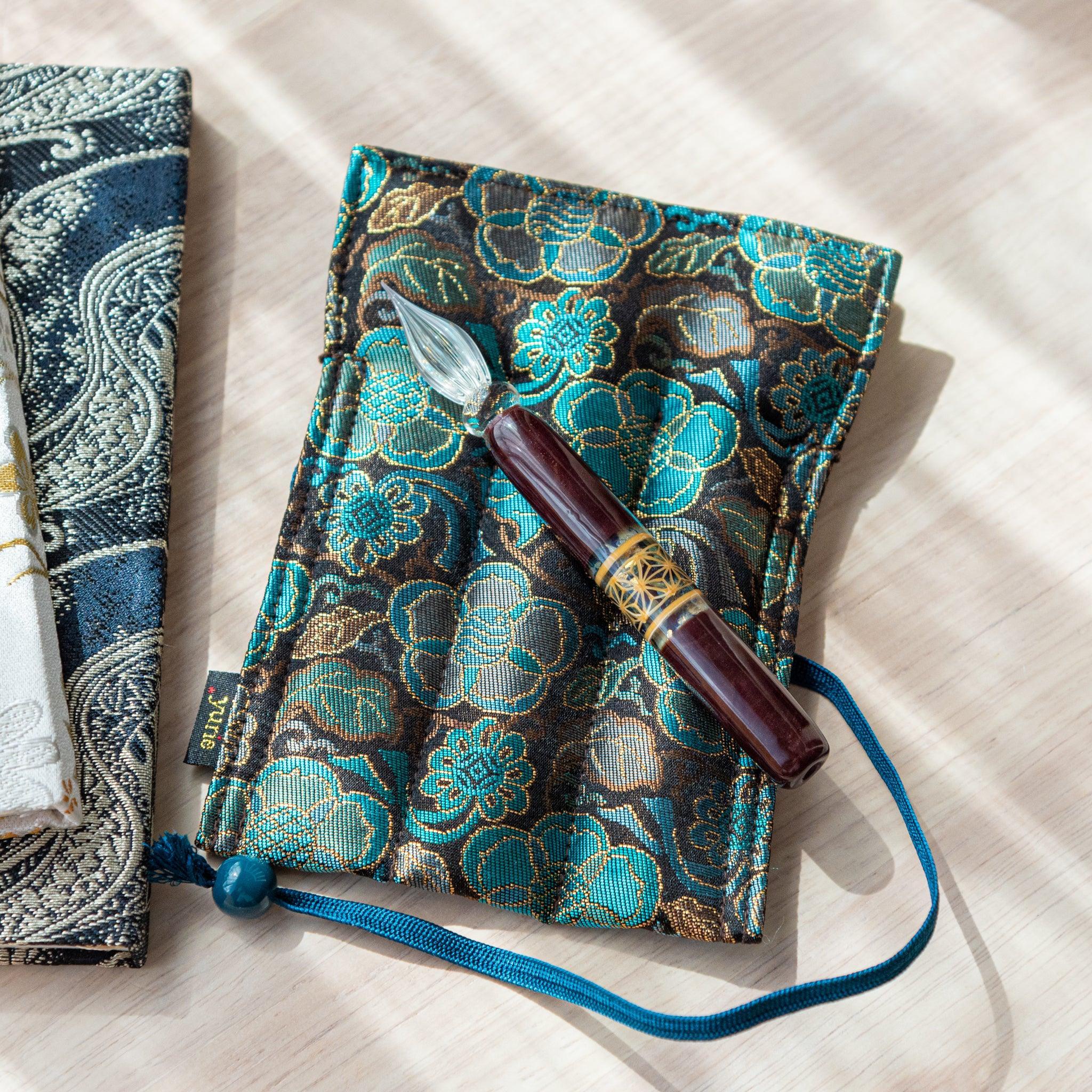 Flatlay of hemp leaves glass dip pen featuring geometric asanoha pattern with twisted glass nib detail in frame