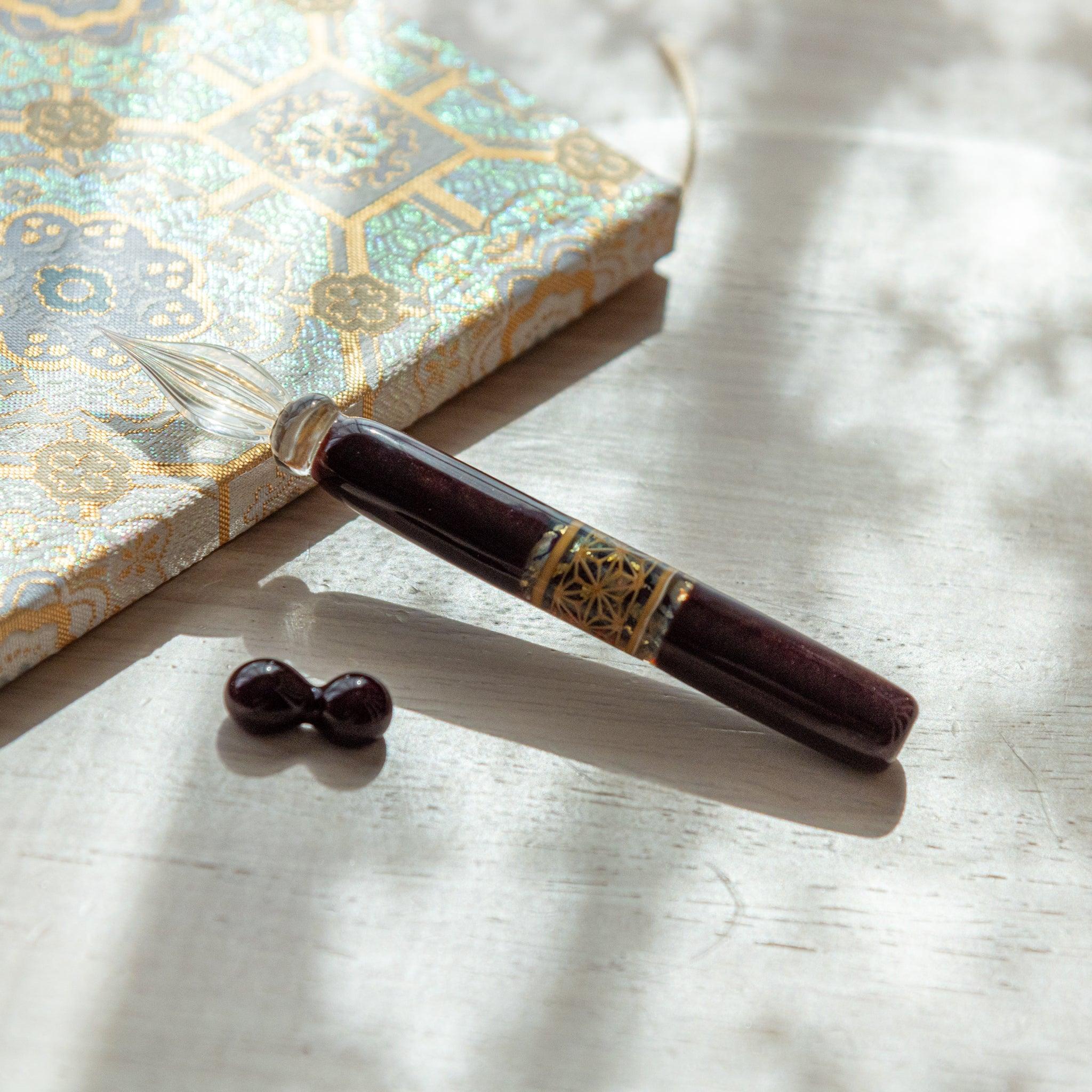 Top view of hemp leaves glass dip pen with matching pen rest showing traditional asanoha design motif visible overall