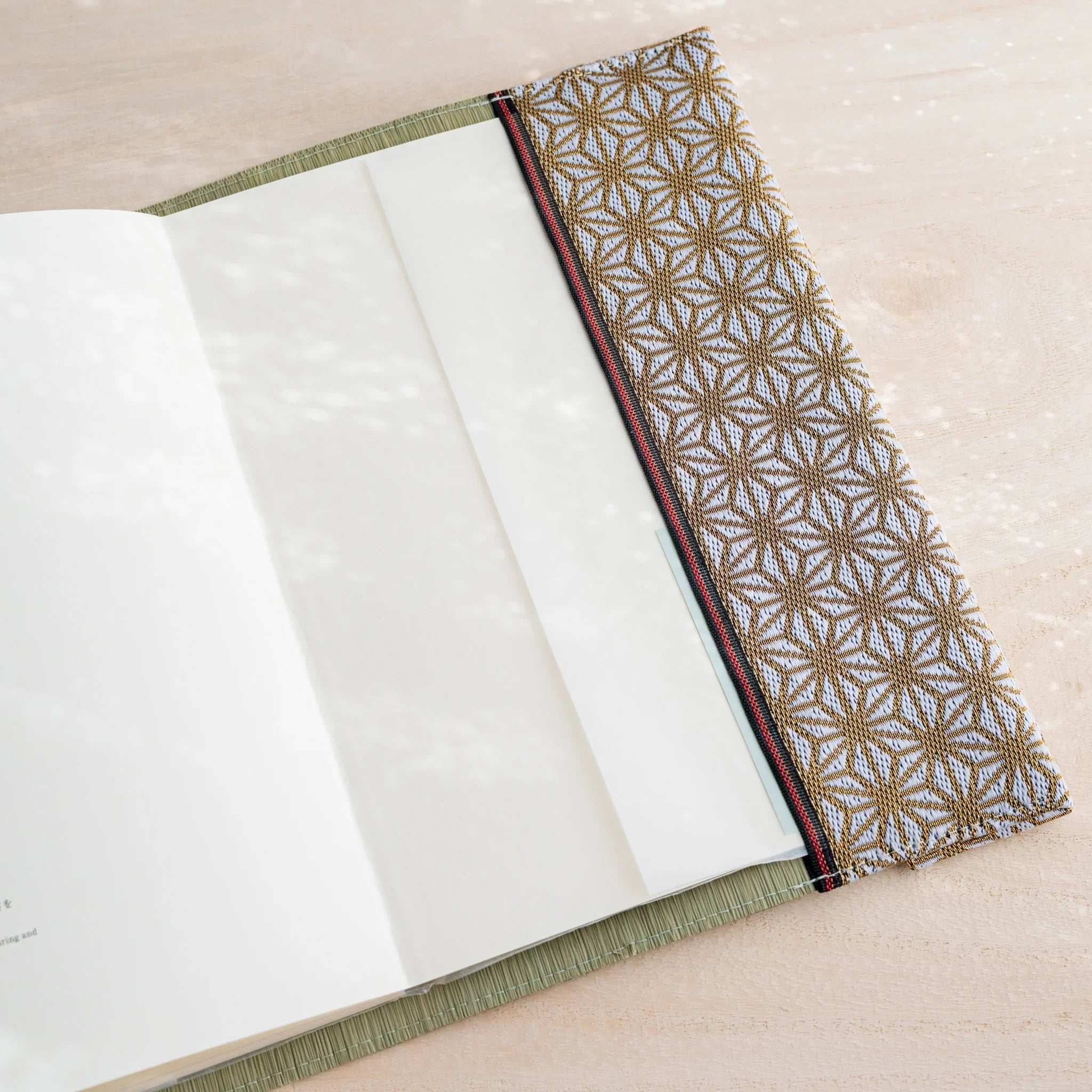 Tatami book cover inner flap open showing notebook end pages and gold and white hemp leaf pattern fabric band