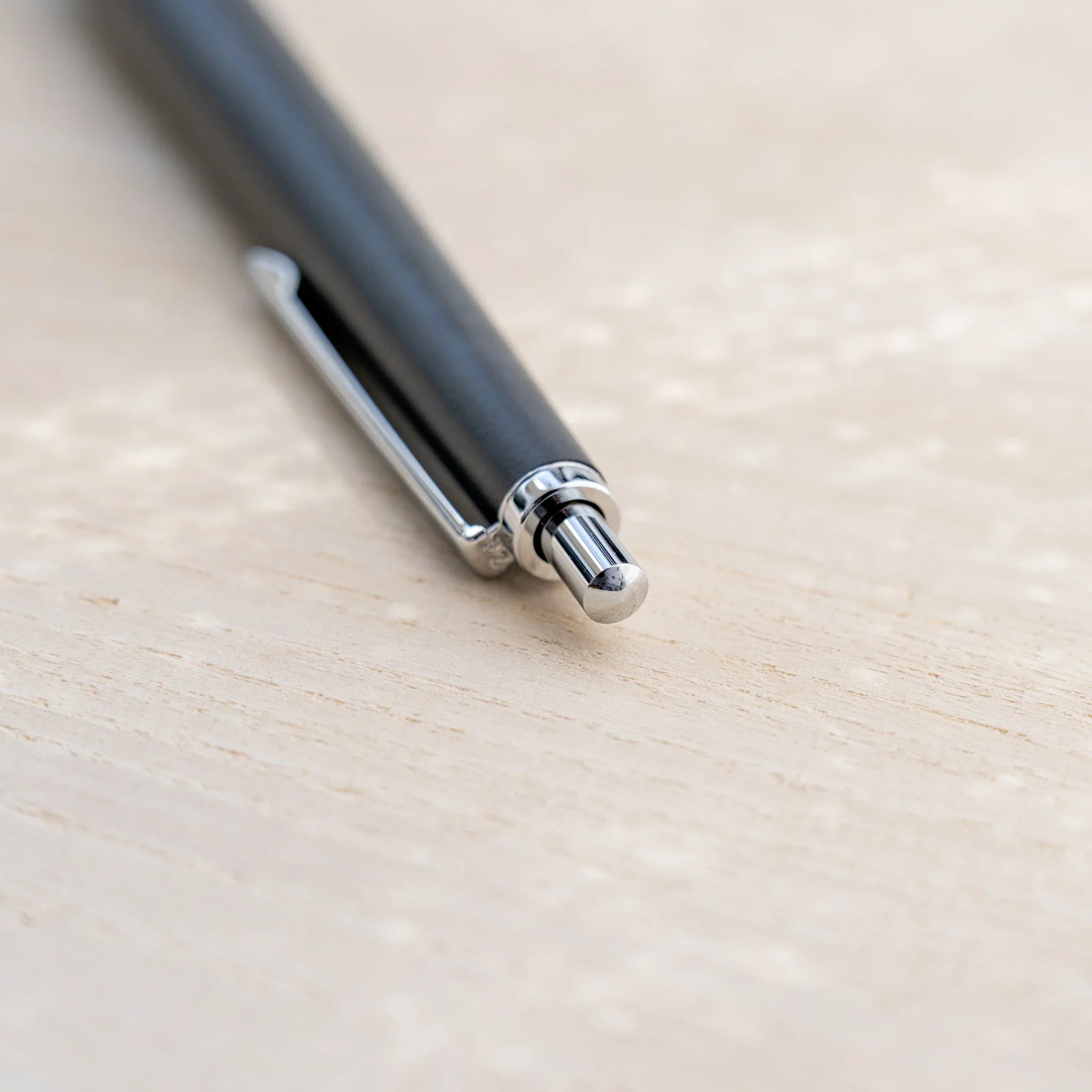 Charcoal black horse chestnut wood urushi ballpoint pen, close-up of knock end and silver clip, Japanese wood