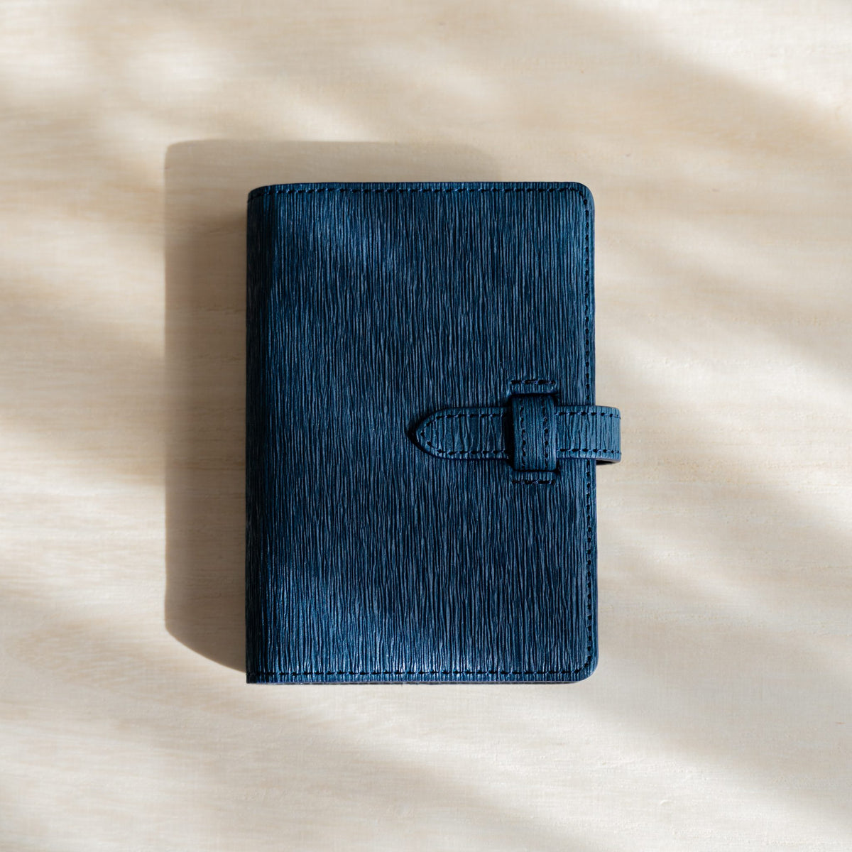 Ise Gikakushi paper leather planner, M5 size in navy, front cover with creases and strap