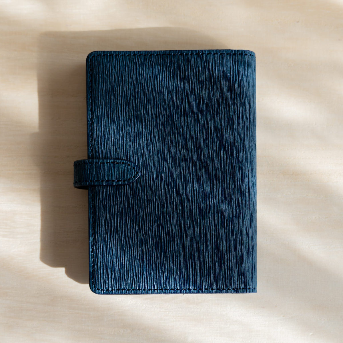 Navy Ise Gikakushi paper leather planner, back cover with the strap tab on the left