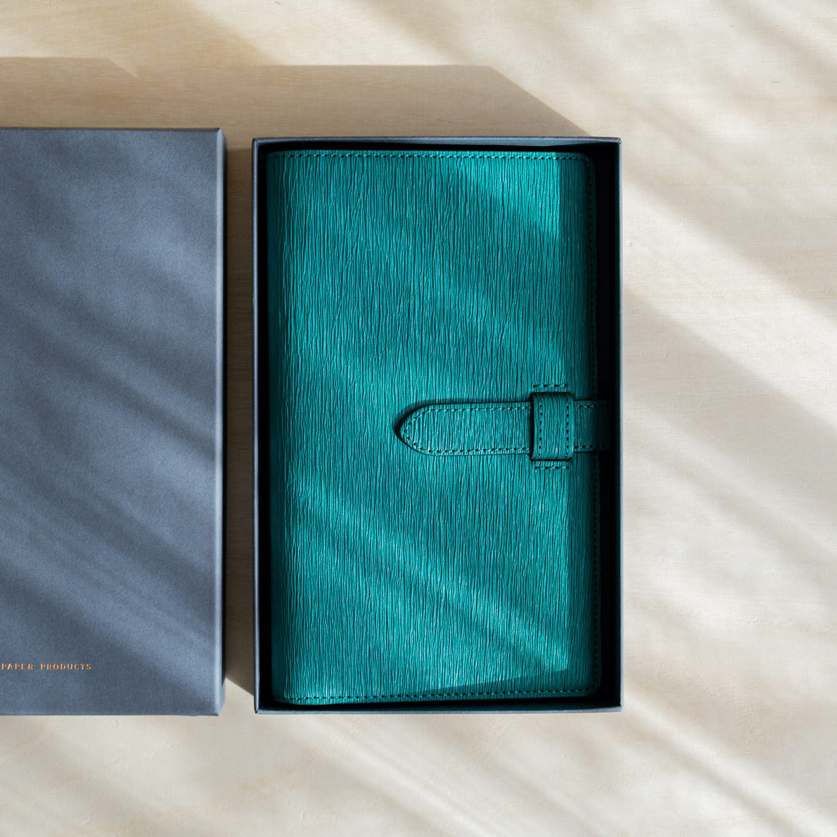 Teal Ise Gikakushi paper leather planner resting in its open gray gift box
