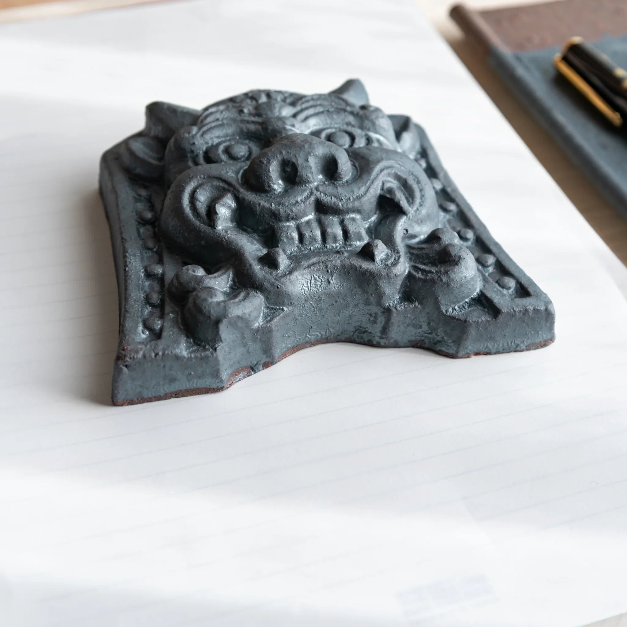 Japanese Kawara large roof guardian ceramic paperweight with resolute expression shown displayed composition view