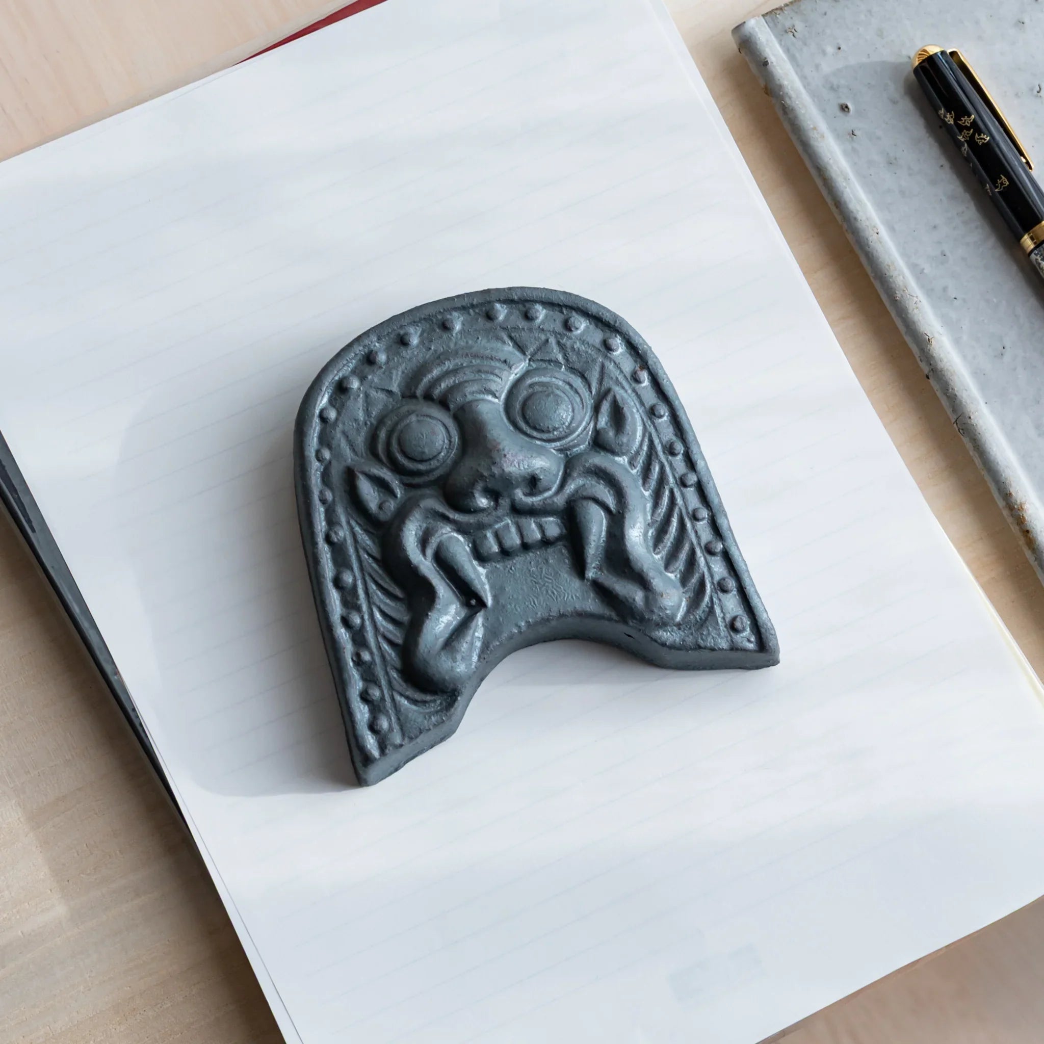 Japanese Kawara large roof guardian ceramic paperweight with steadfast expression shown shown in composition