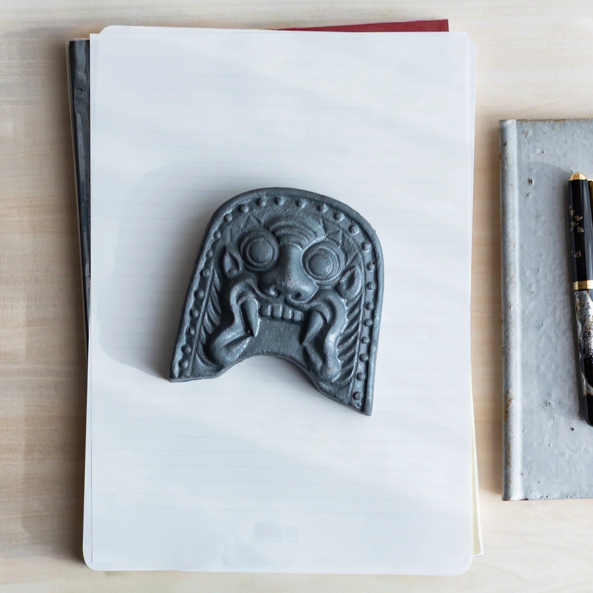 Japanese Kawara large roof guardian ceramic paperweight with steadfast expression shown displayed in composition