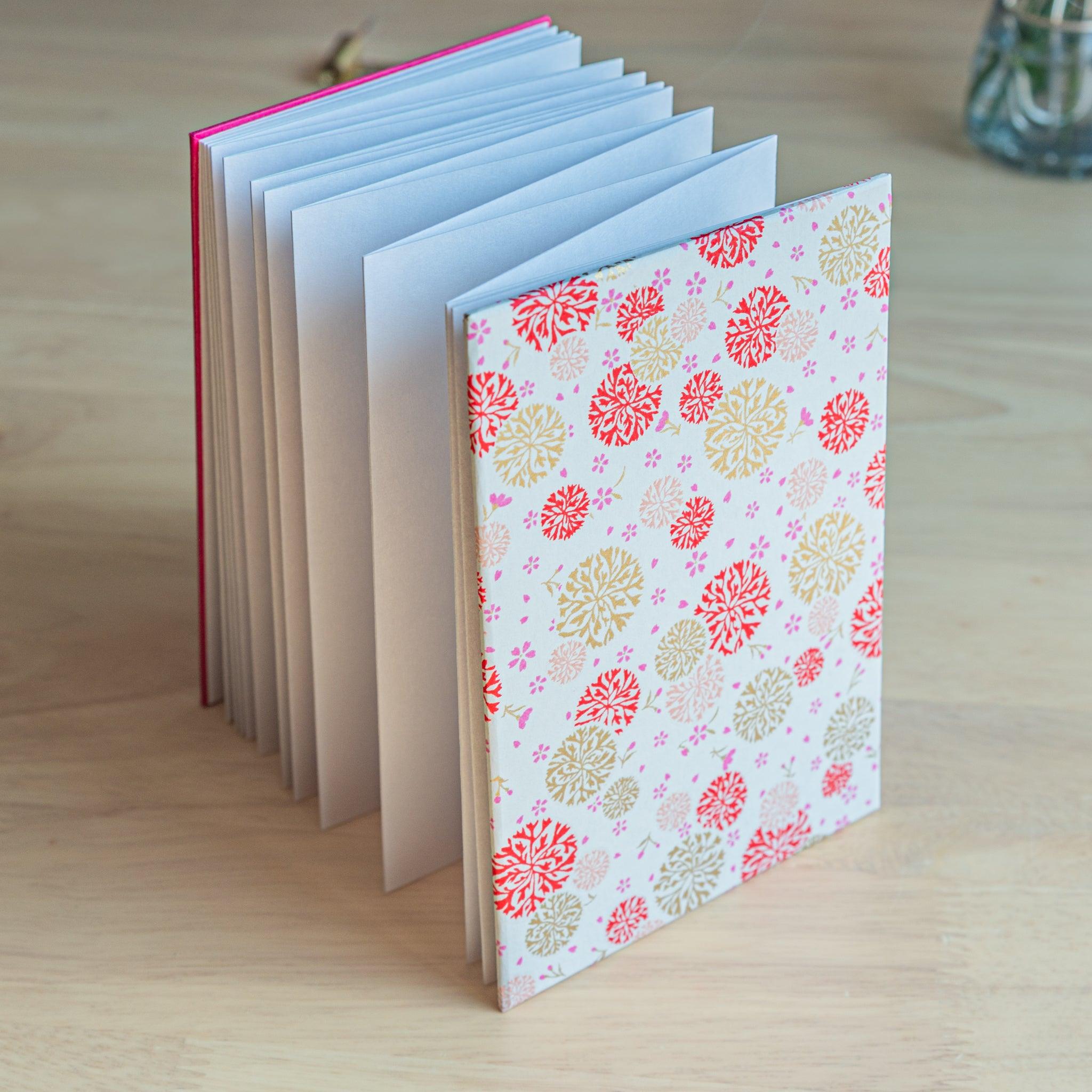 Accordion-style Japanese Goshuinsho stamp book featuring soft blue cover and chrysanthemum washi pattern for temple stamps.