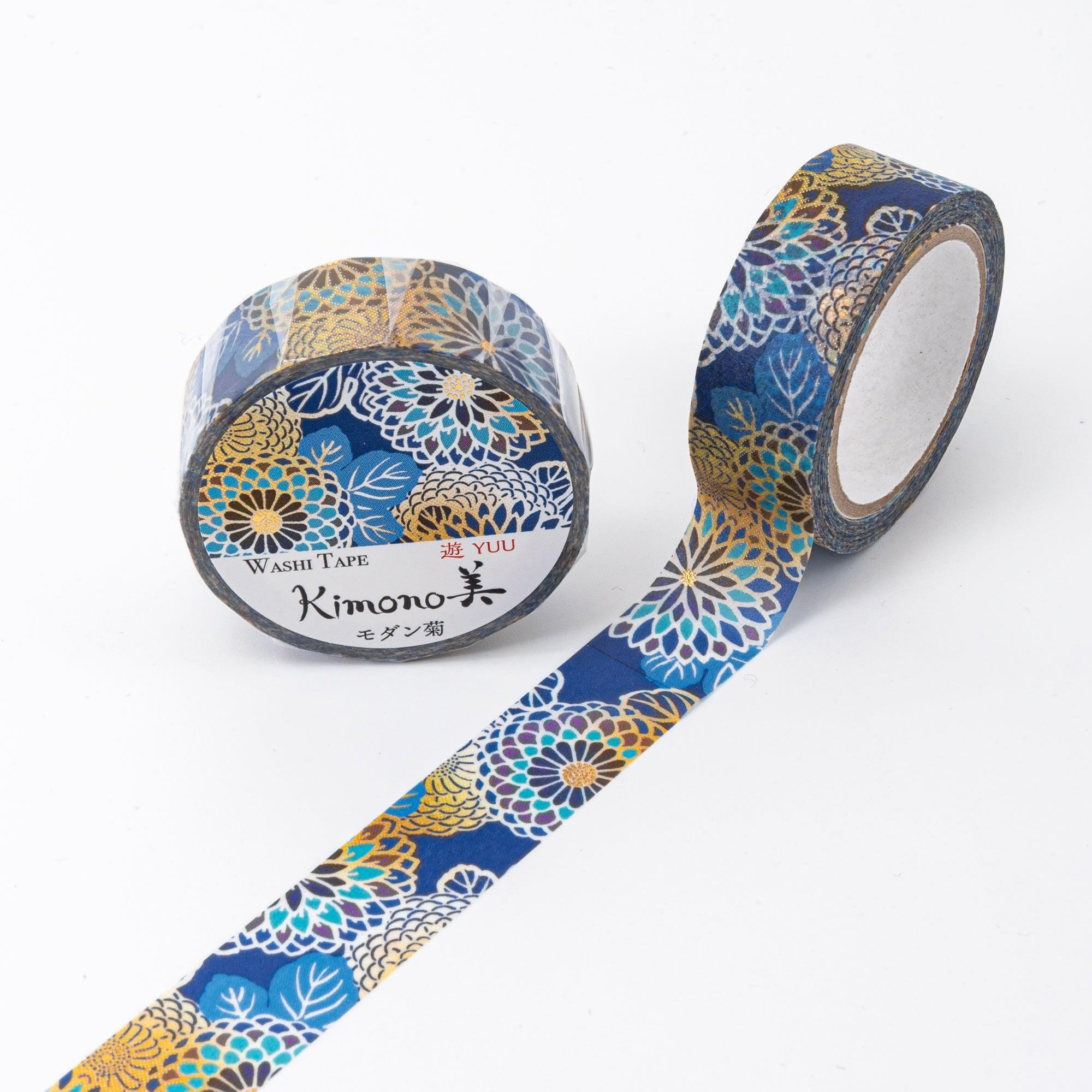 Unrolled Japanese stationery washi tape showcasing detailed chrysanthemum designs in vibrant gold, blue, and white tones on a dark background.