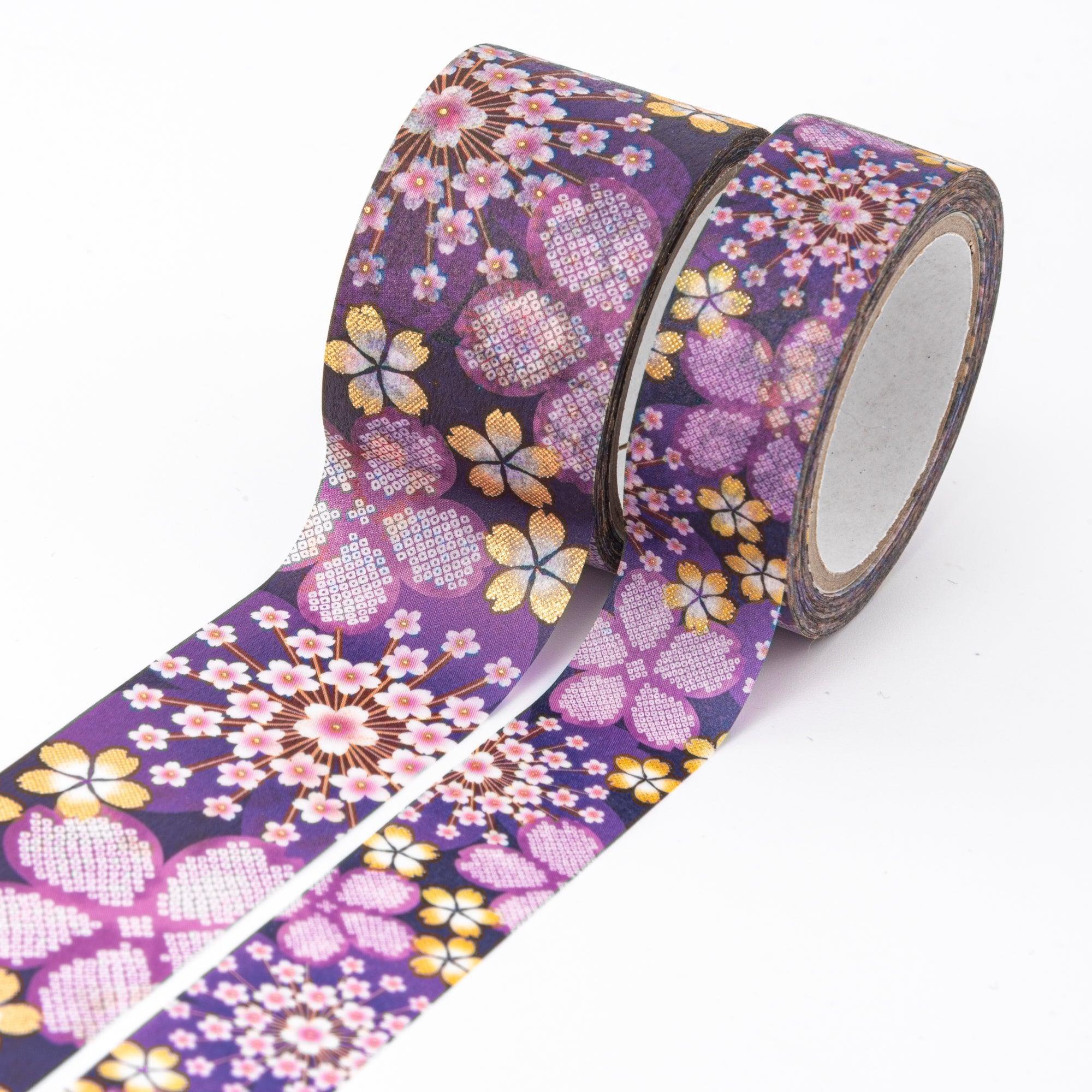 Close-up of Japanese stationery washi tape highlighting vibrant sakura designs and golden accents with detailed floral patterns on a purple background.
