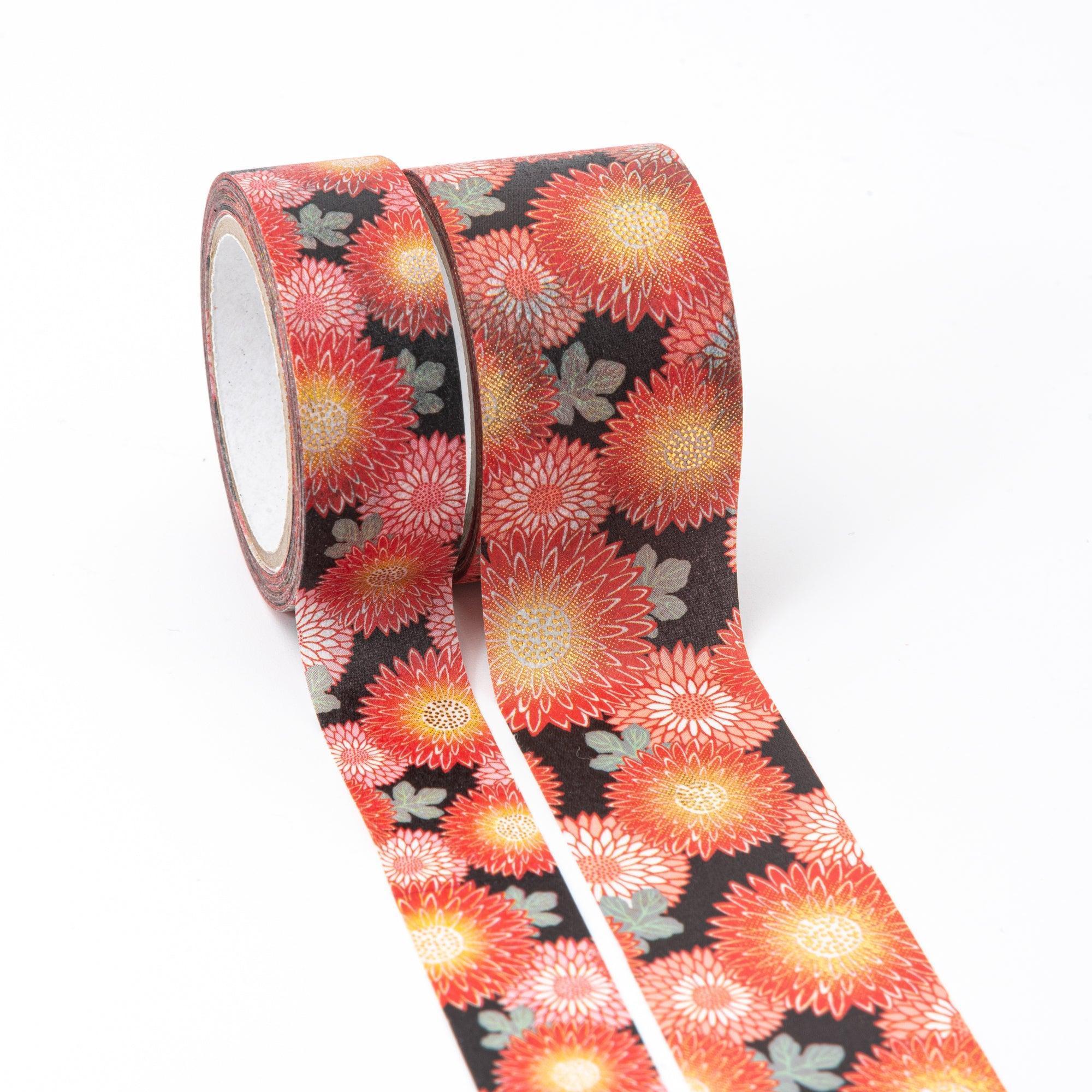 Two rolls of Japanese stationery washi tape showcasing bold chrysanthemum patterns in red, orange, and gold, set against a rich black background.