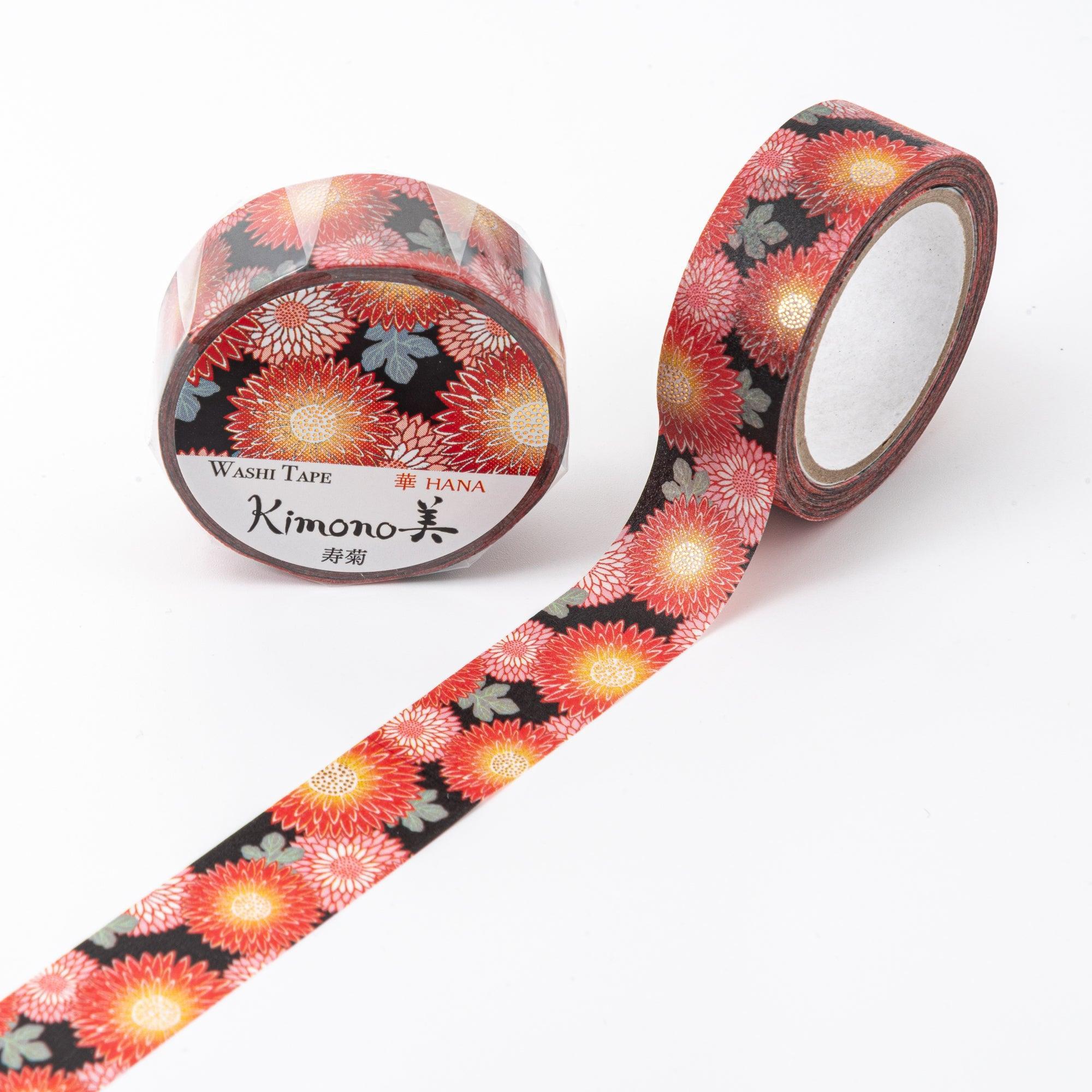 Unrolled Japanese stationery washi tape featuring detailed chrysanthemum motifs in warm red and gold tones with green leaves on a black base.