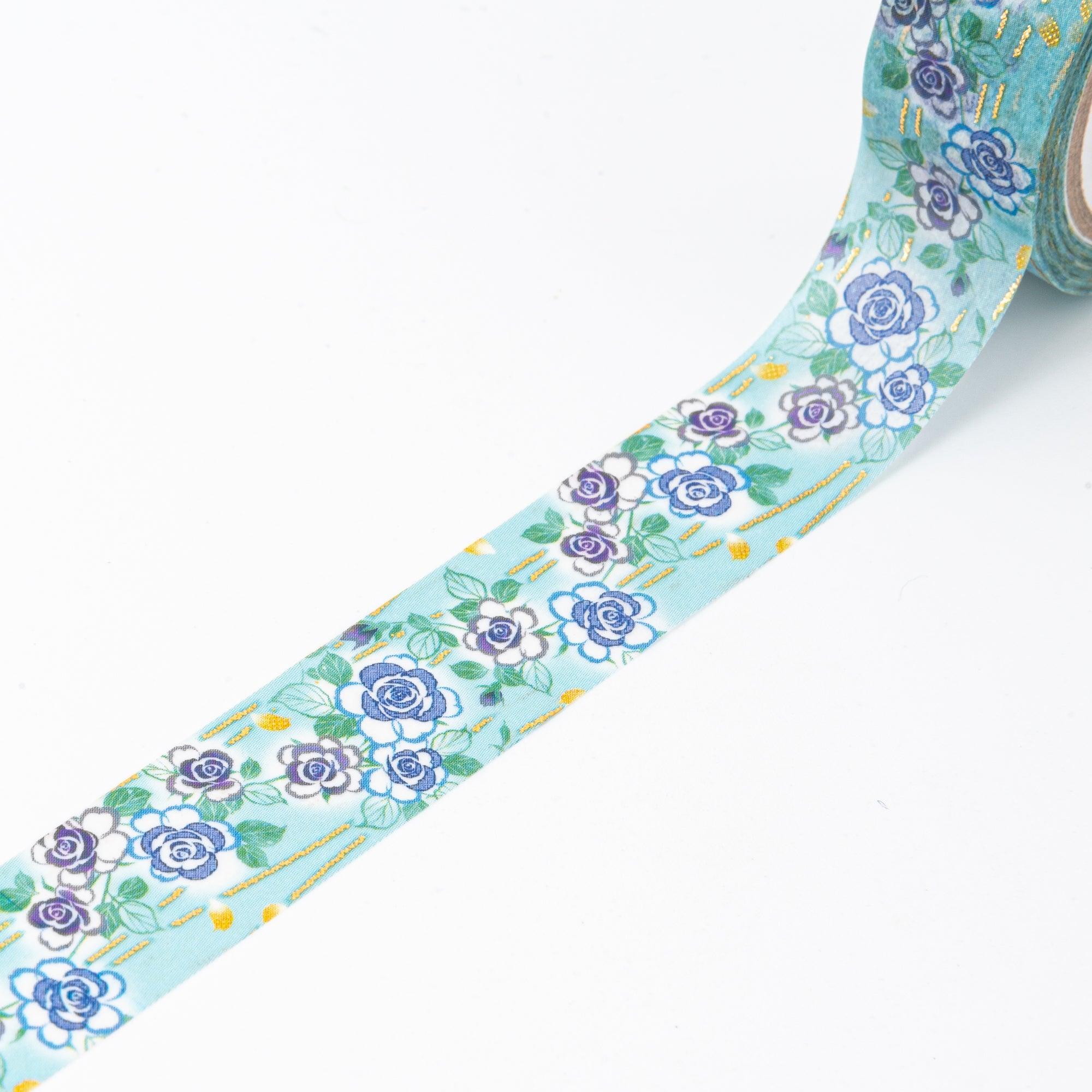 Close-up of a floral washi tape roll with blue roses and golden details, emphasizing the intricate design used in Japanese stationery.