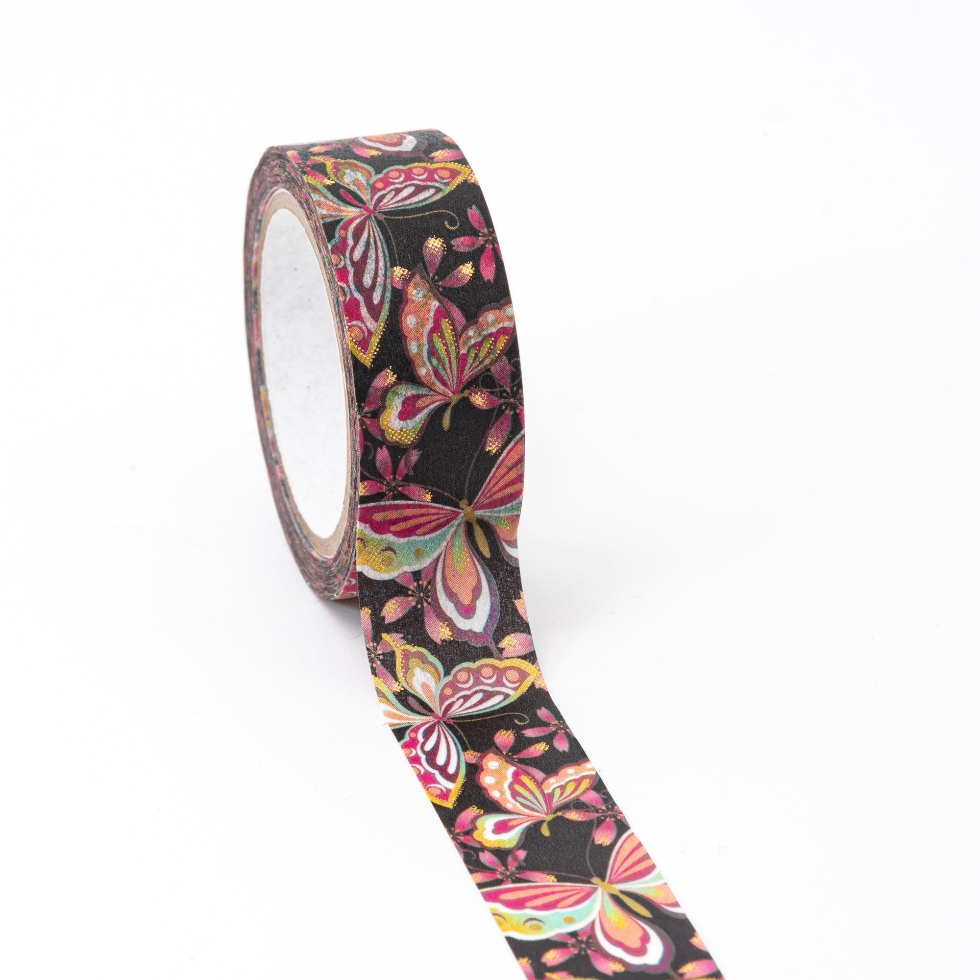 Unrolled washi tape with vivid butterfly designs and gold accents on a black background, highlighting the beauty of traditional Japanese stationery.