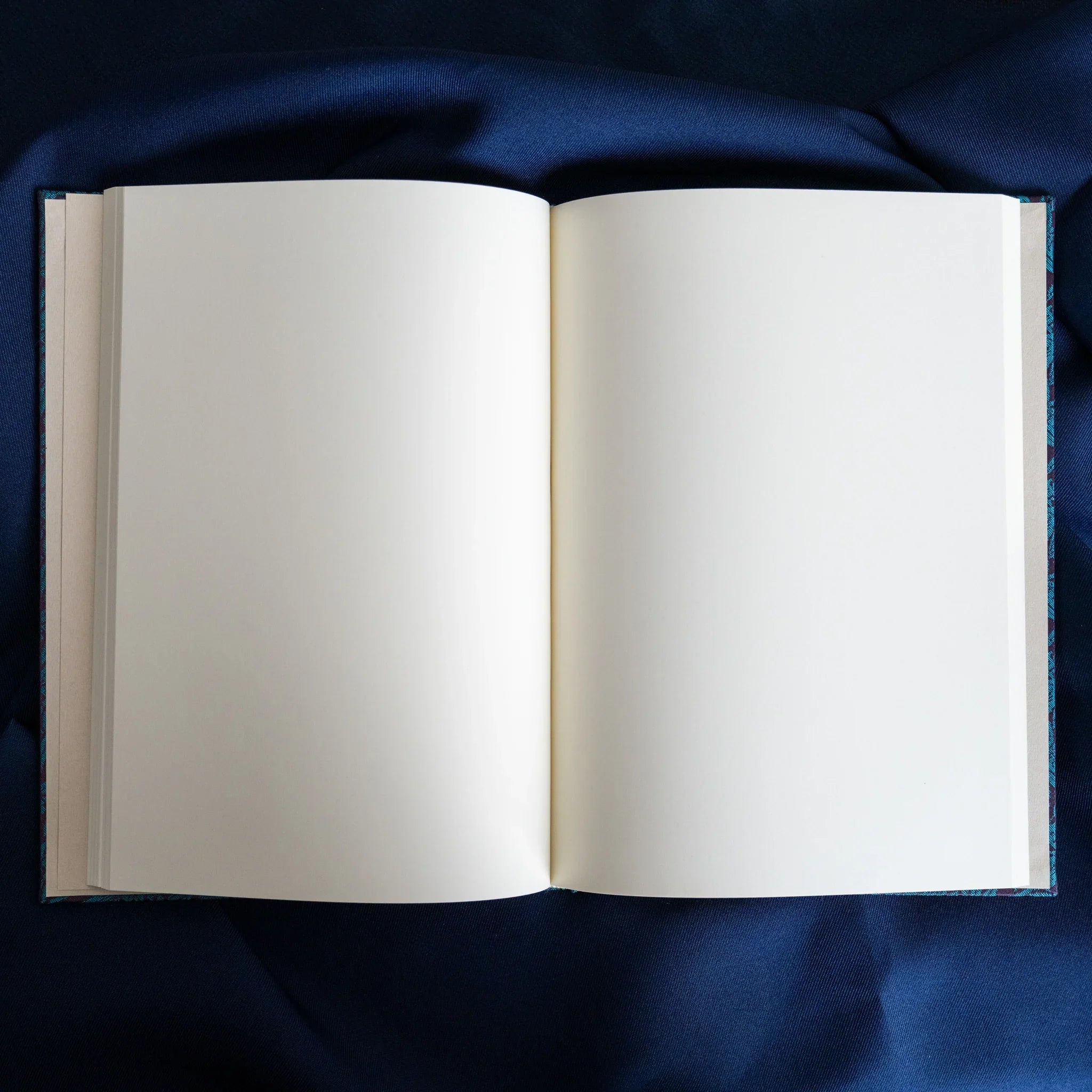 Kiri Take Ho-o Nishijin silk Homeicho notebook open showing blank white page spread with teal cover binding on navy fabric