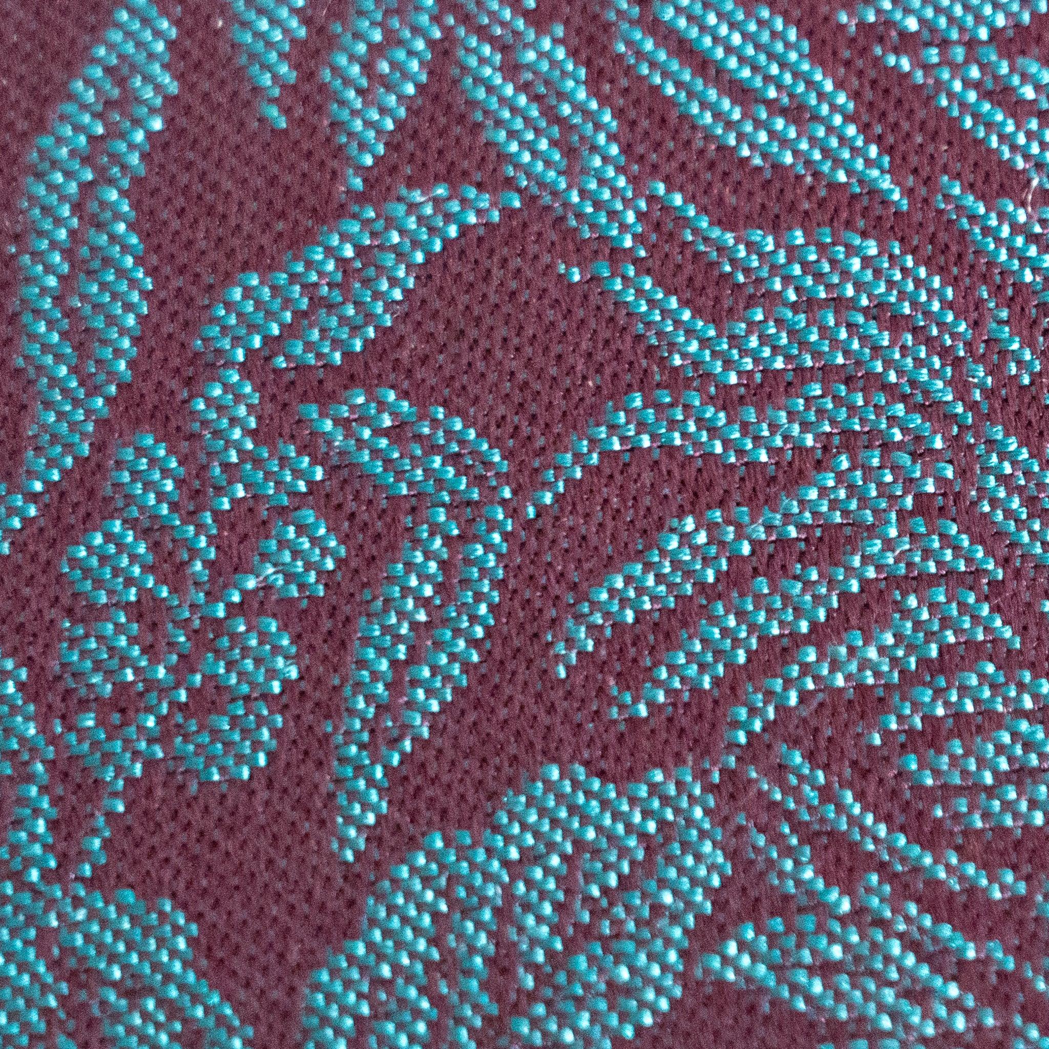 Extreme macro close-up of Kiri Take Ho-o Nishijin silk weave showing teal threads on maroon ground with leaf pattern