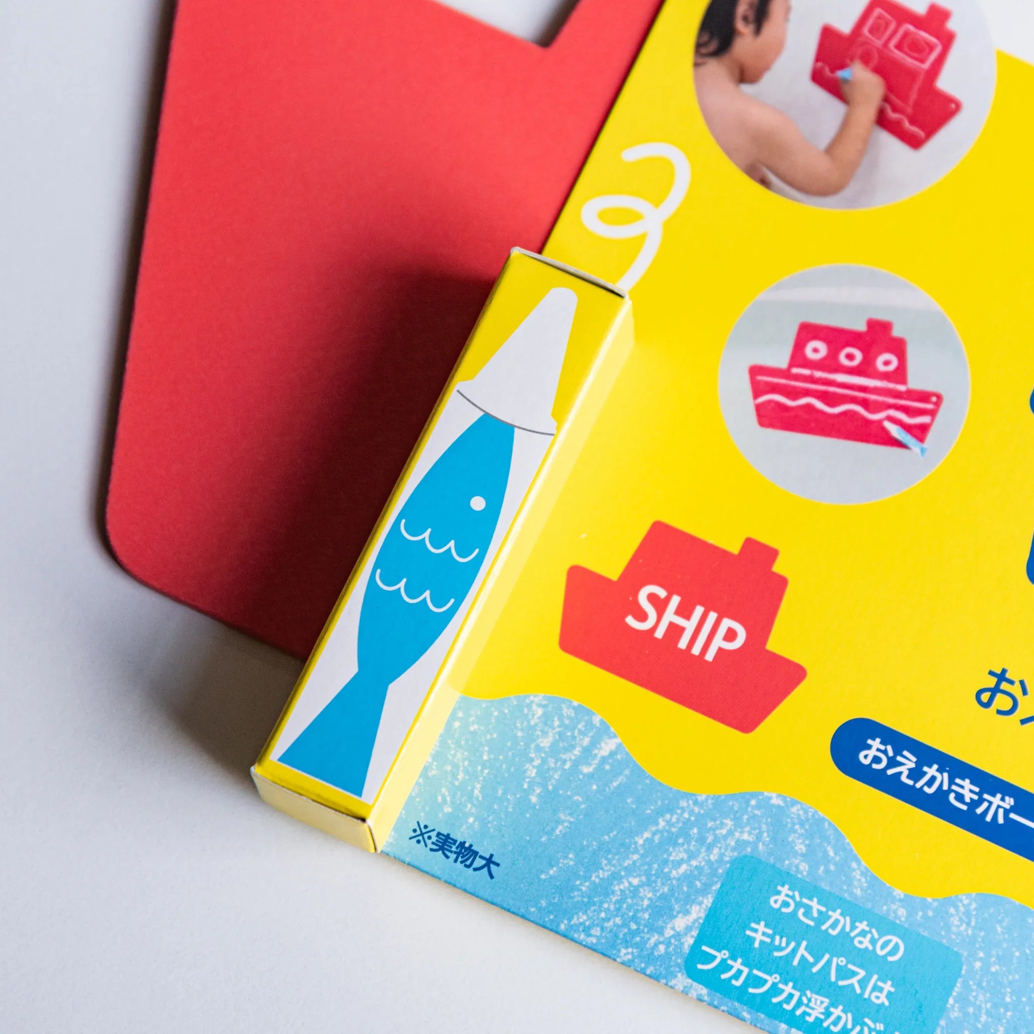 Kitpas bath drawing board kit packaging with a yellow box featuring waves and fish, red ship-shaped board behind.