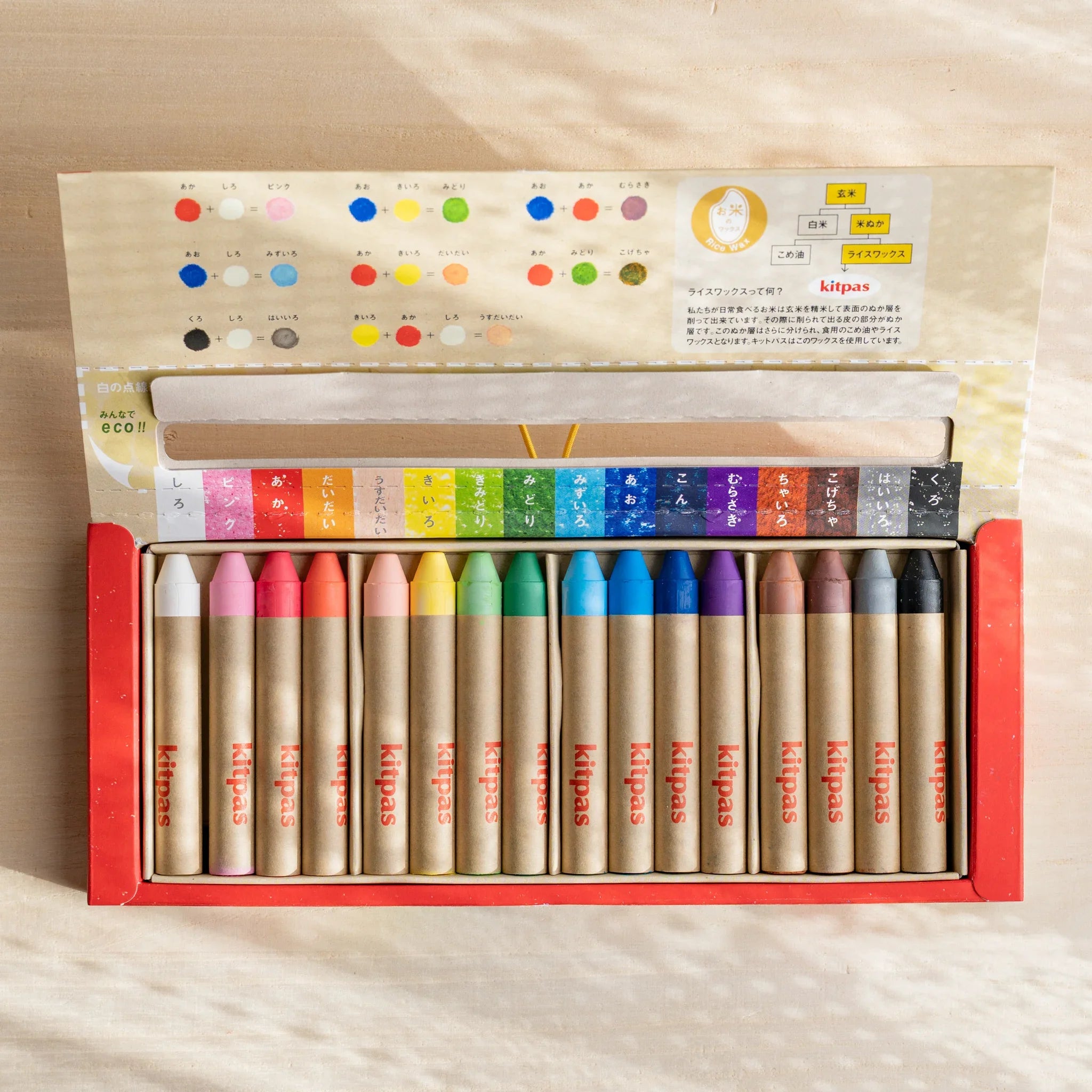 Kitpas watercolor crayons arranged in a fan showing the complete color range from red to purple hues