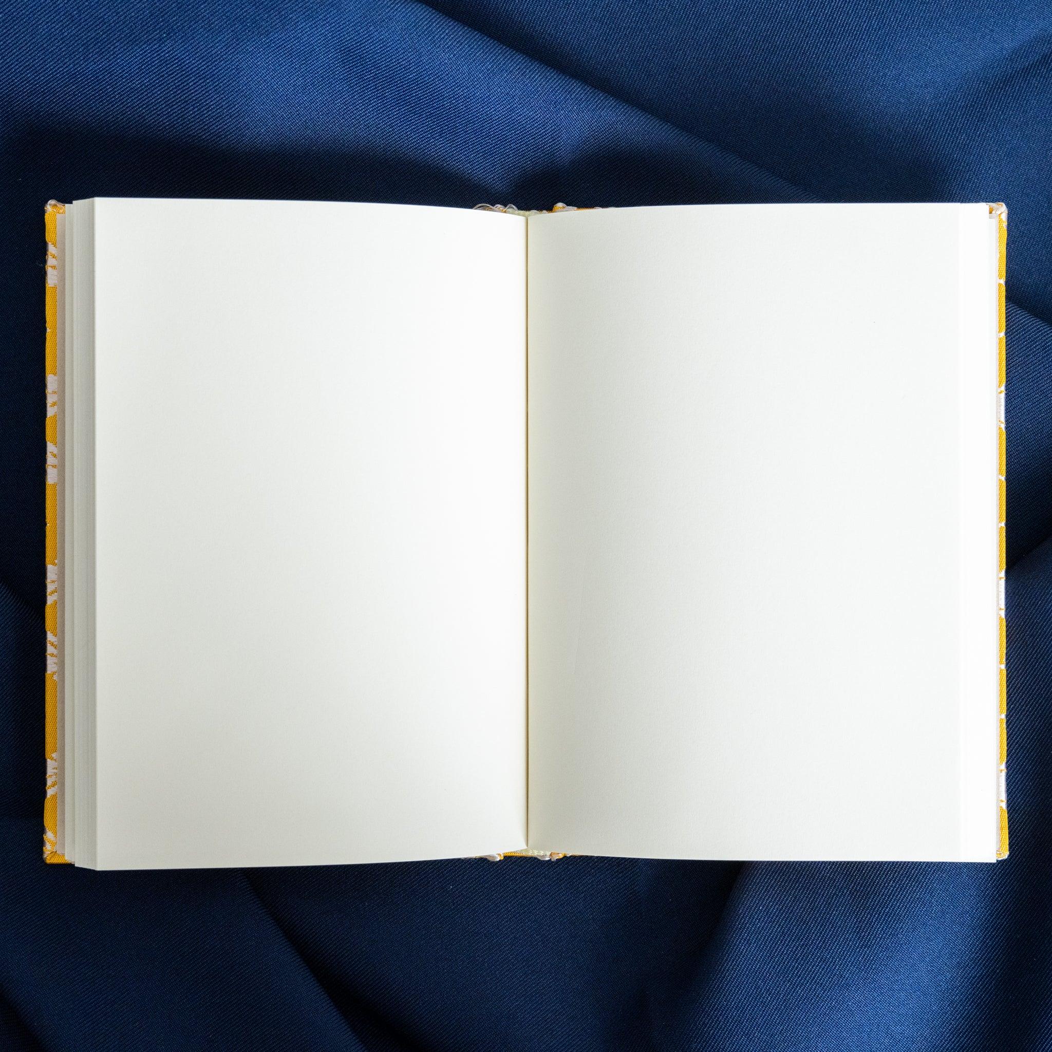 Ko Aoi Nishijin silk Homeicho notebook open spread showing white blank pages fully framed by golden Ko Aoi silk cover