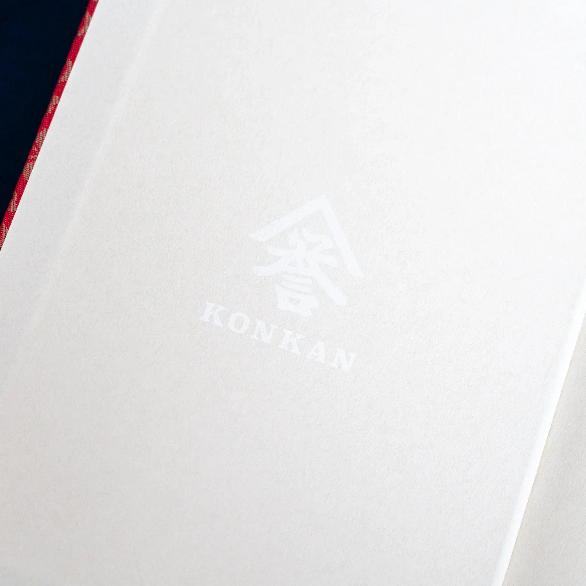 Ko Aoi Nishijin silk notebook paper band interior showing cream striped texture with KONKAN watermark logo