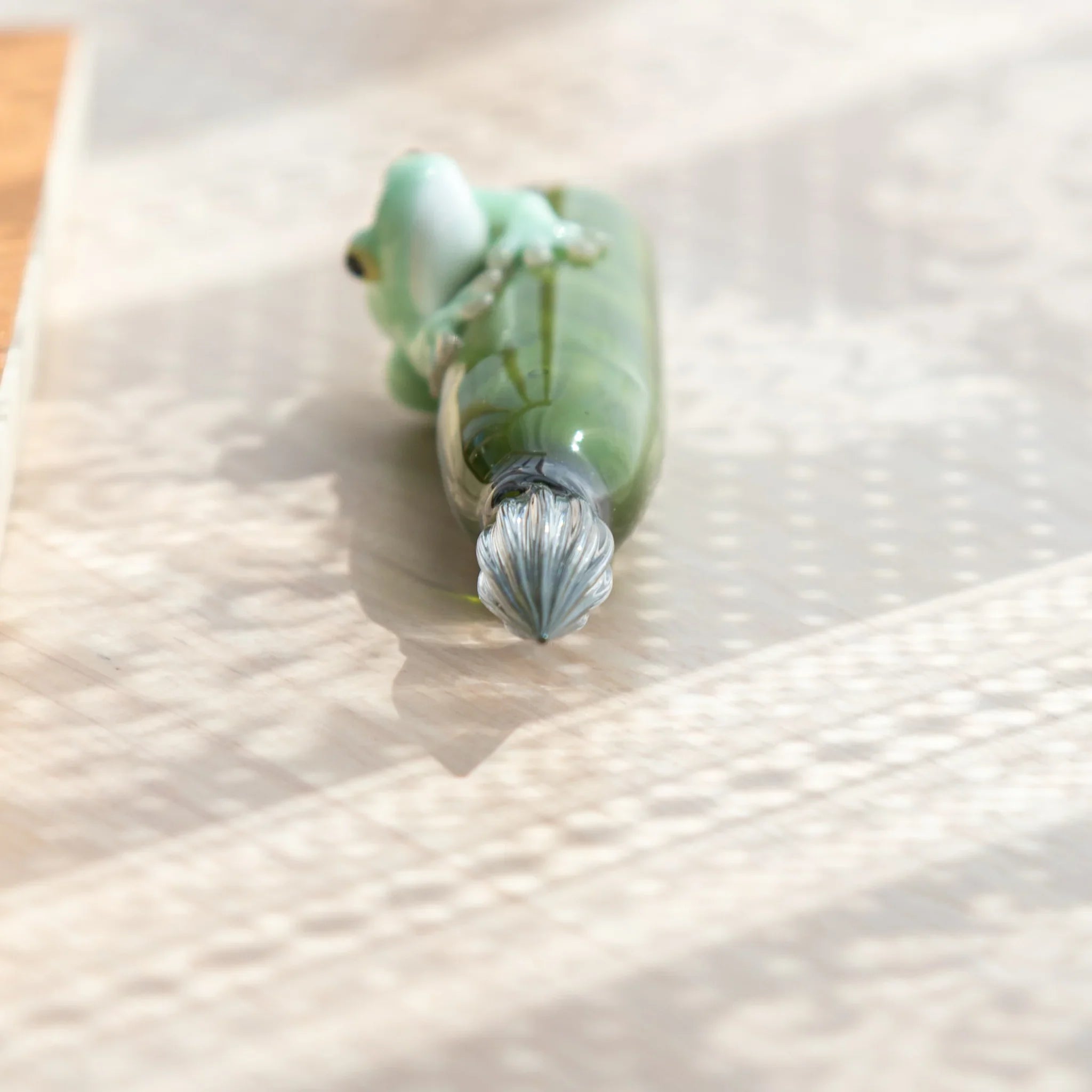 Decorative dip pen with detailed resin work featuring pale green creature on vibrant glass with wooden