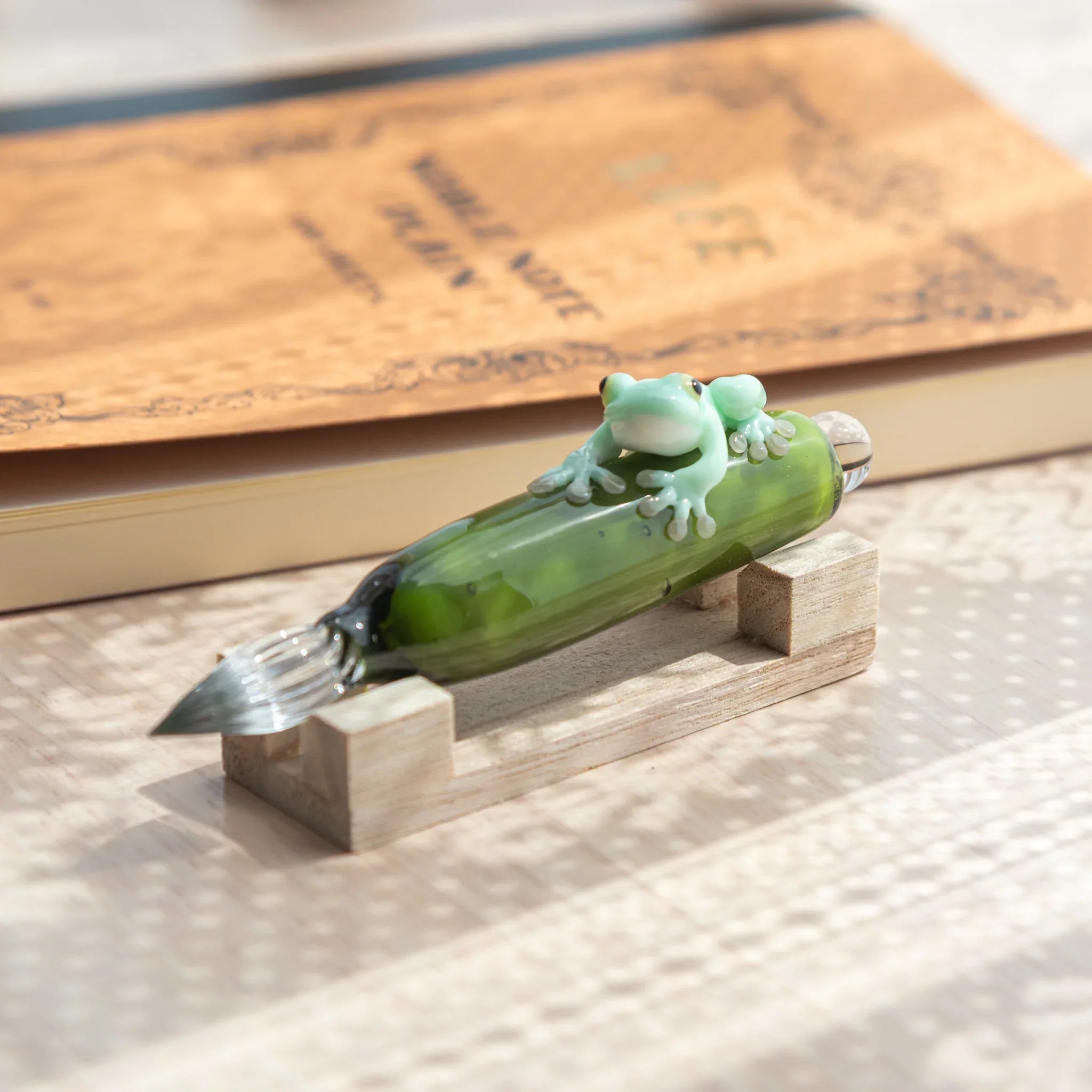 Japanese frog glass dip pen combining detailed resin creature with hand-blown green glass components