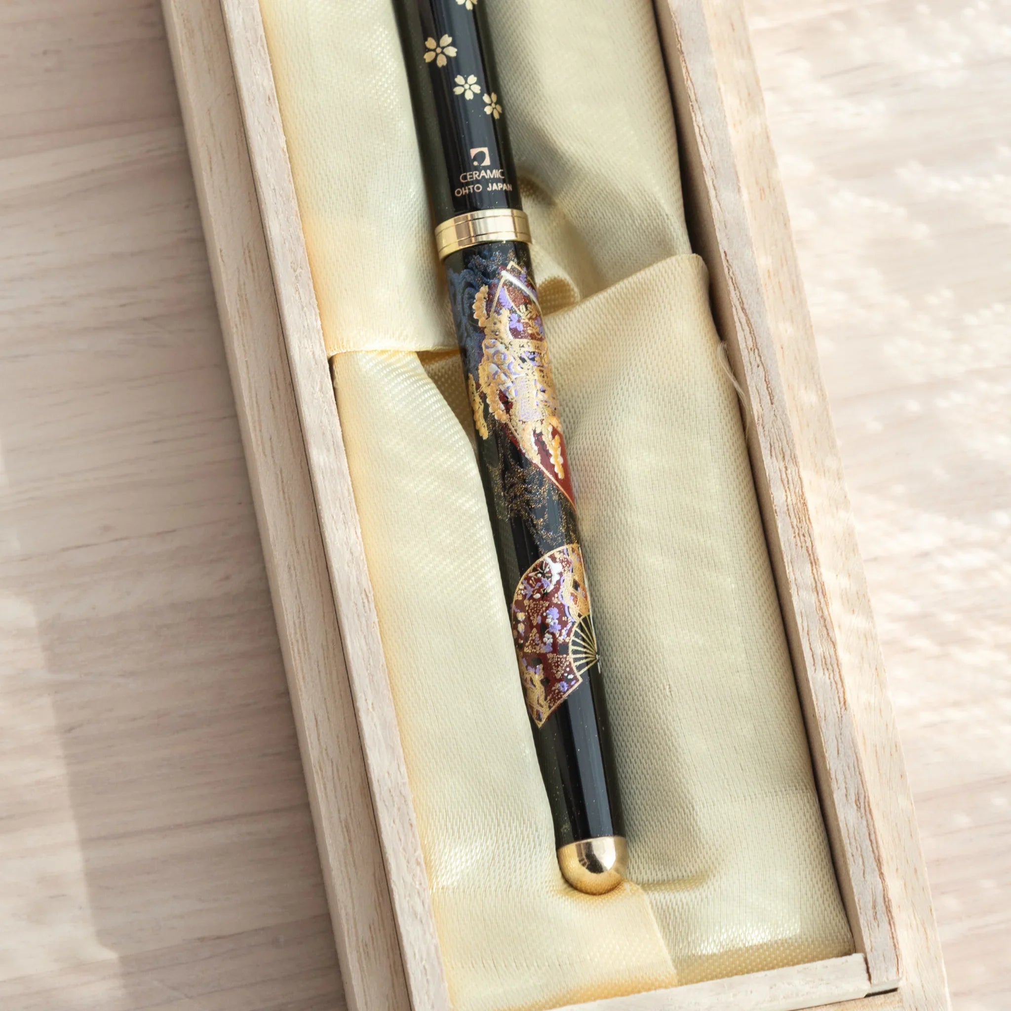 Close-up of a Japanese Ballpoint Pen adorned with gold Lacquer cherry blossoms and elegant folding fan motif.