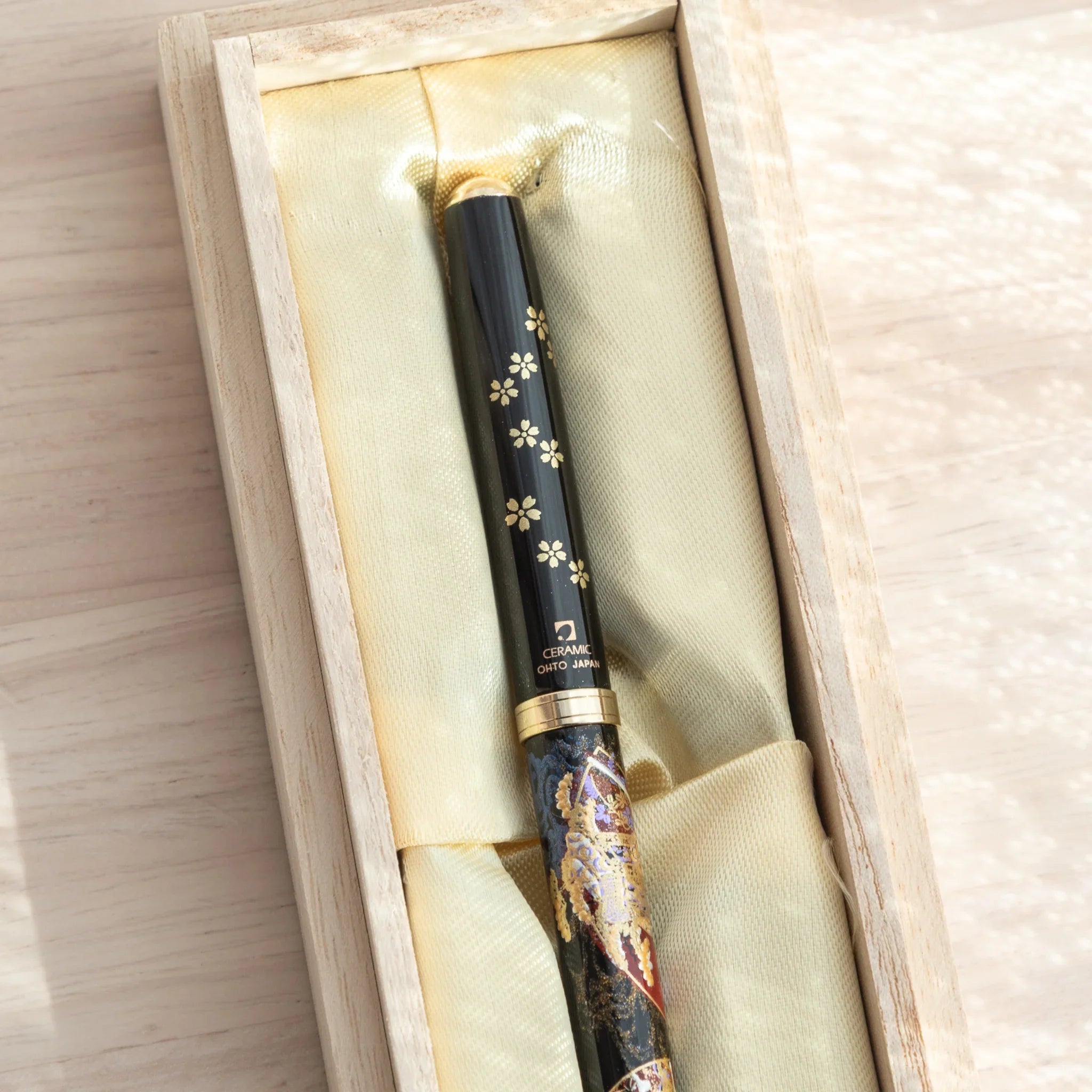 Close-up of a Japanese Ballpoint Pen adorned with gold Lacquer cherry blossoms and elegant folding fan motif.