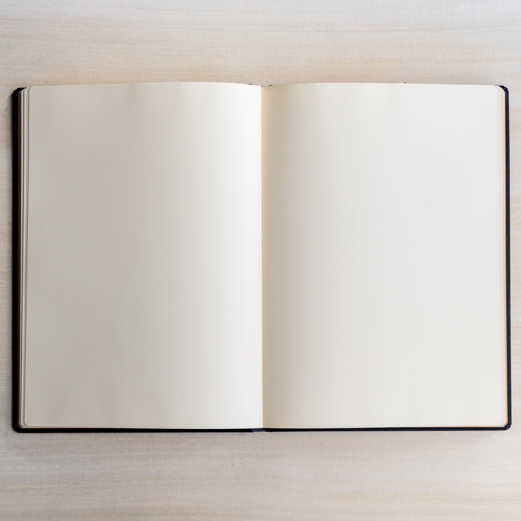 Life Noble notebook A5 open flat on light wood desk, cream pages ready for journaling, planning, and writing