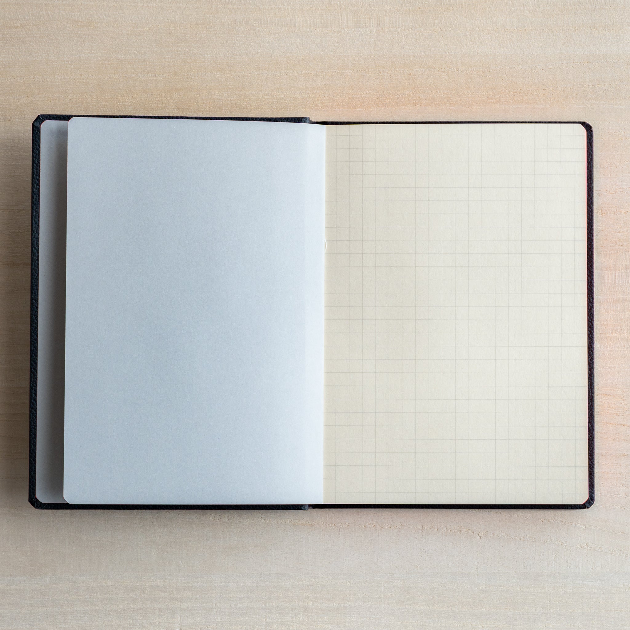 Life Noble notebook A6 open flat with grid L Writing Paper, showing pale gray flyleaf and compact layout for neat writing