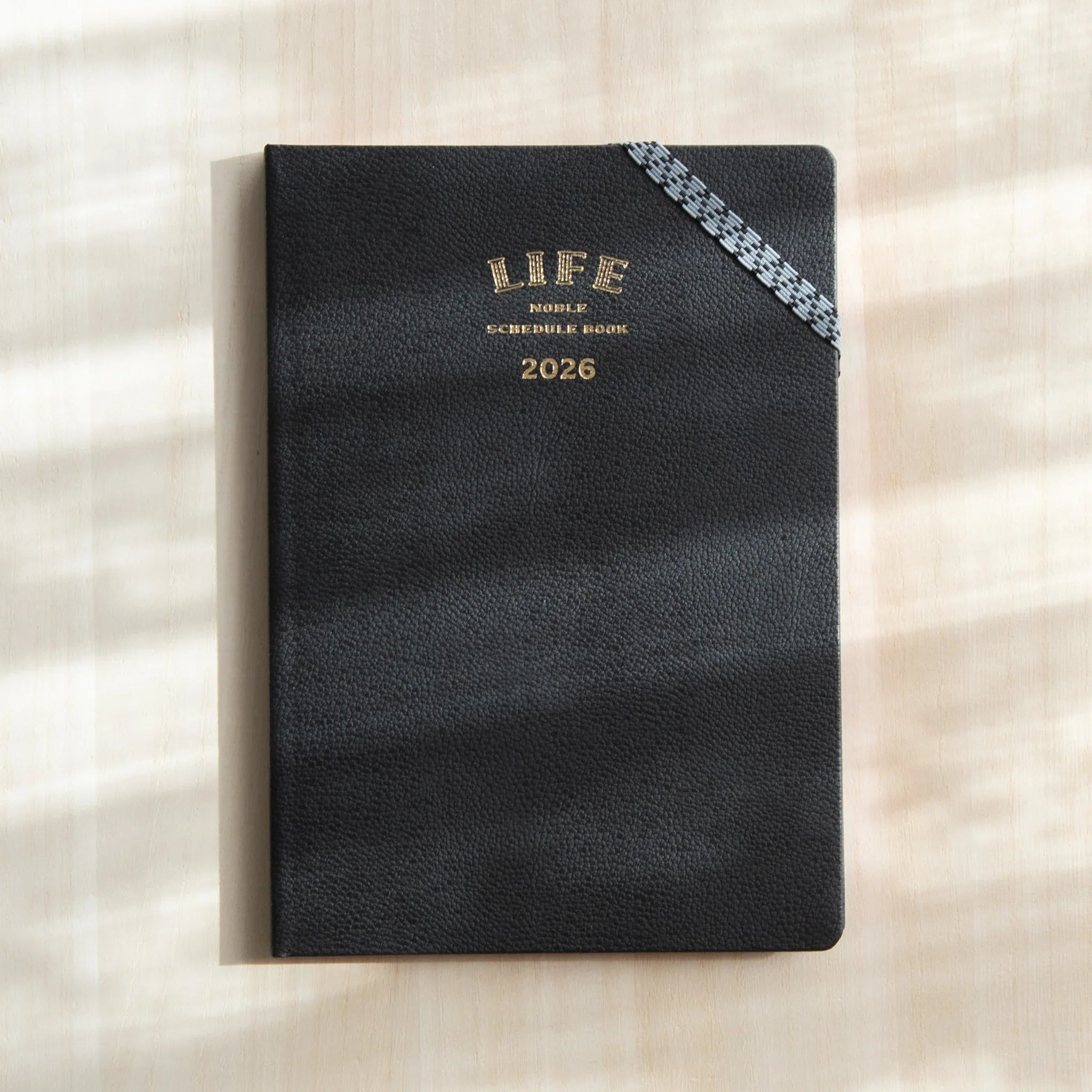Front cover of the LIFE Noble Planner 2026 Japanese Planner with black textured finish and gold stamped title.