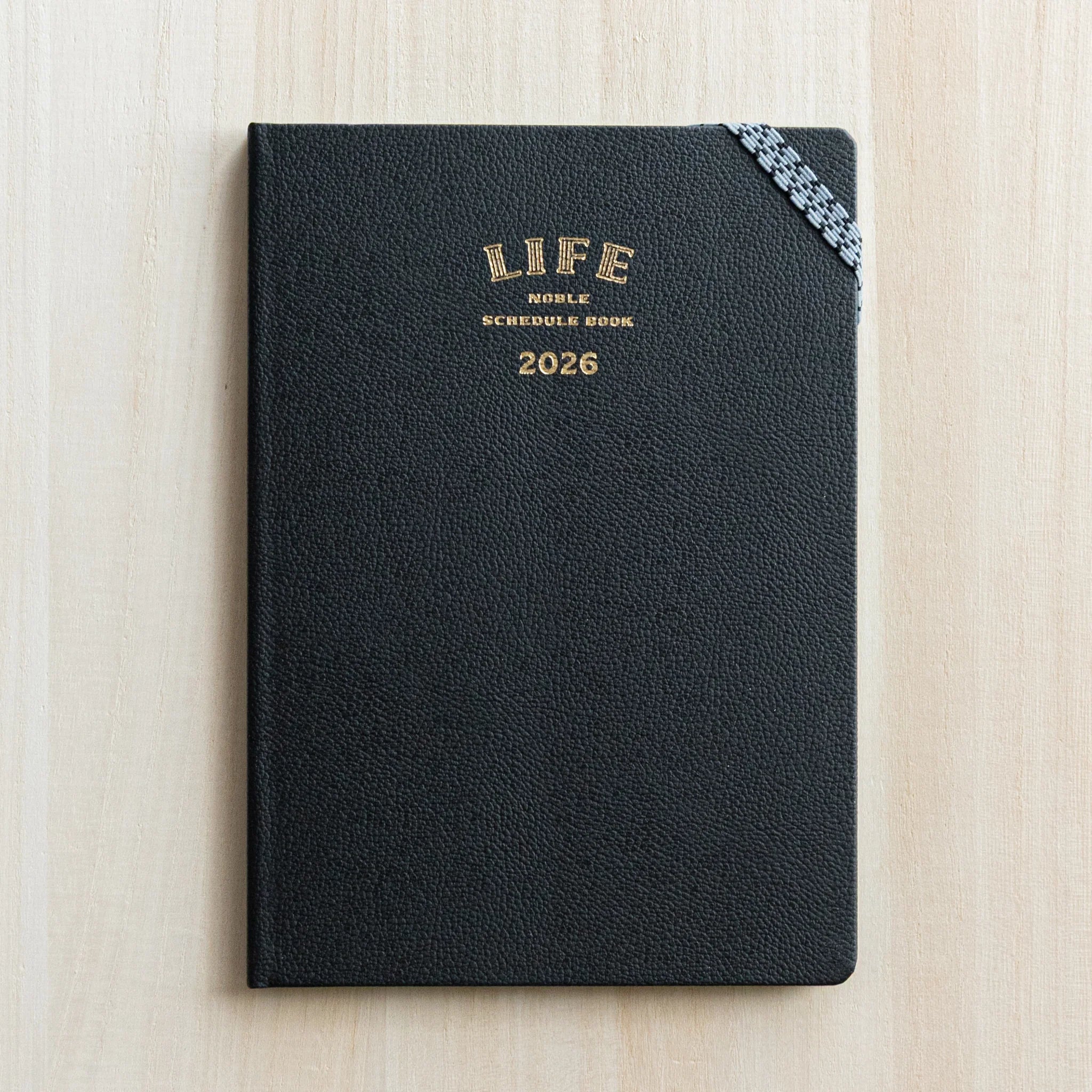 Life Noble planner for 2026 in dark navy, flat lay display with embossed text