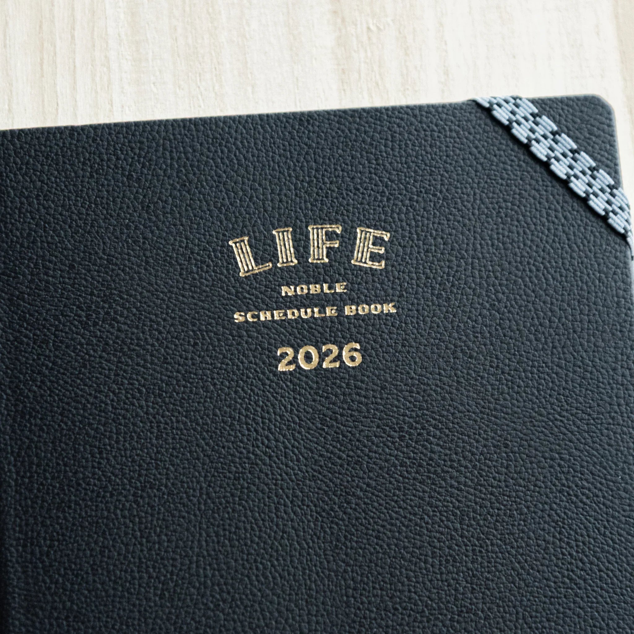 Life Noble 2026 planning notebook, dark navy cover, flat lay display highlighting embossed text