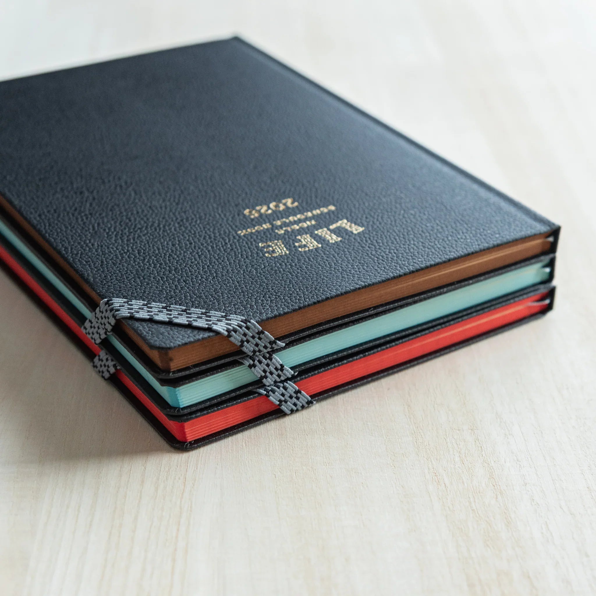 Stacked LIFE Noble Planner 2026 editions showing different page edge colors, stylish Japanese Planner set.