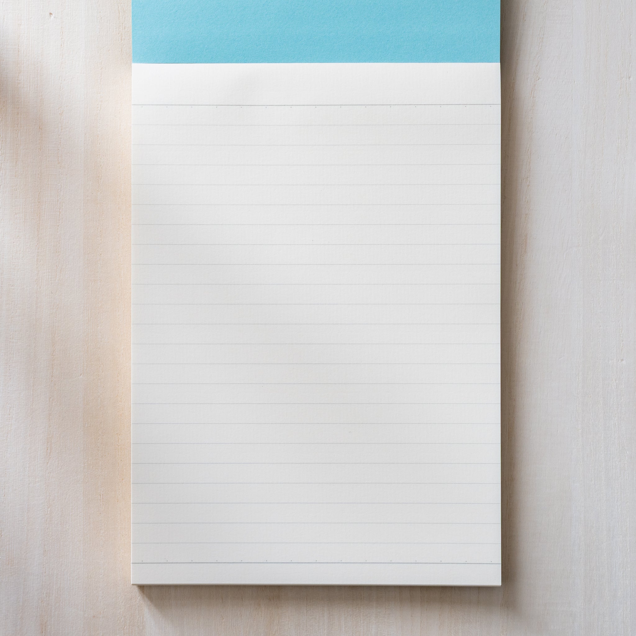 Life Noble writing pad lined page shown flat with blue header and evenly spaced lines, smooth Japanese paper for daily writing