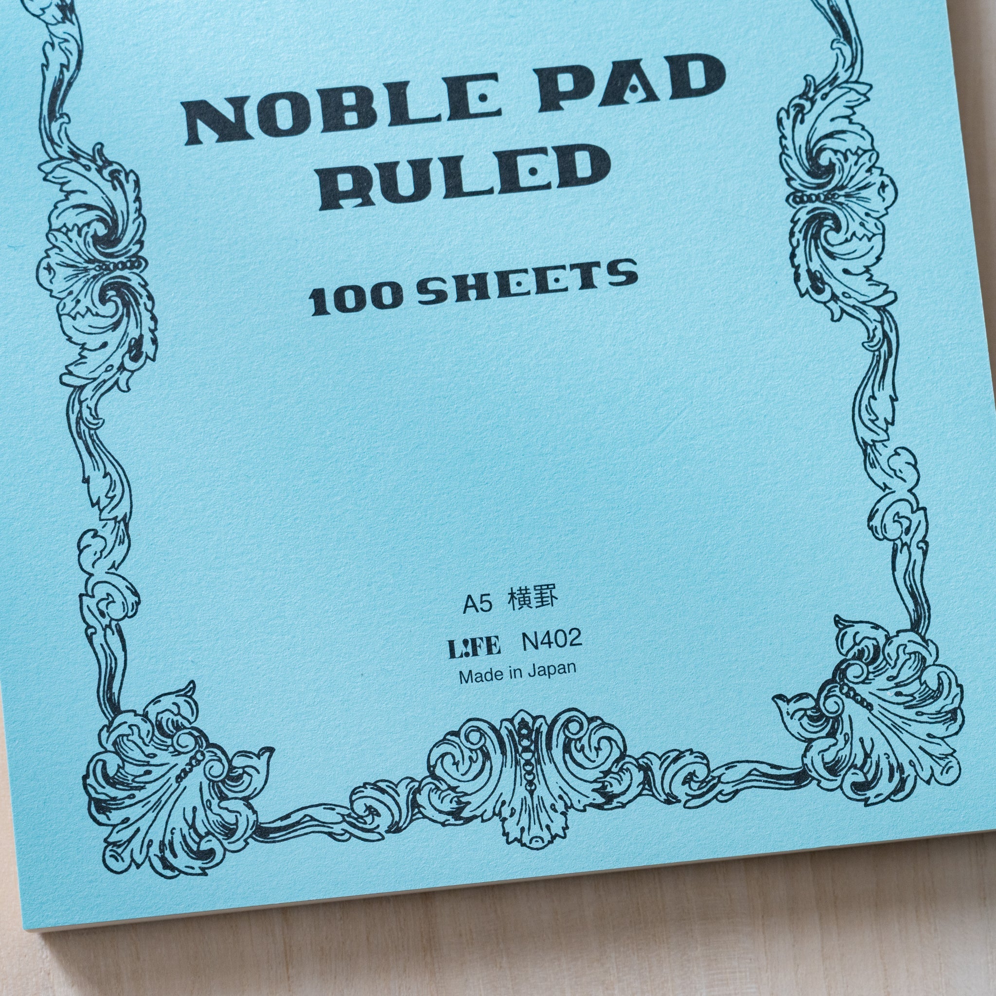 Life Noble writing pad ruled cover in light blue showing NOBLE PAD lettering and vintage frame, A5 Japanese stationery pad