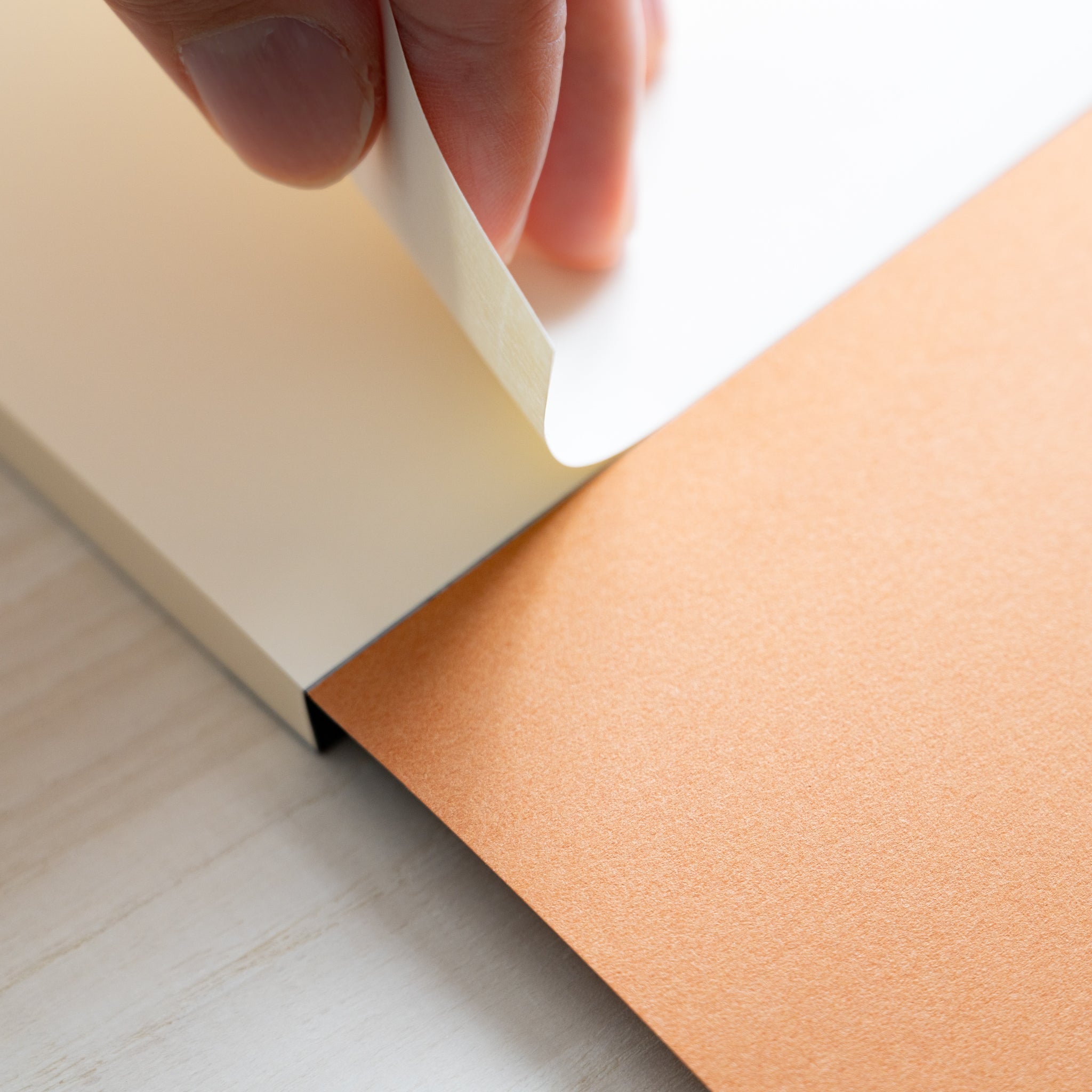 Life Noble writing pad showing hand lifting smooth cream sheet, fountain pen friendly Japanese paper with clean tear-off edge