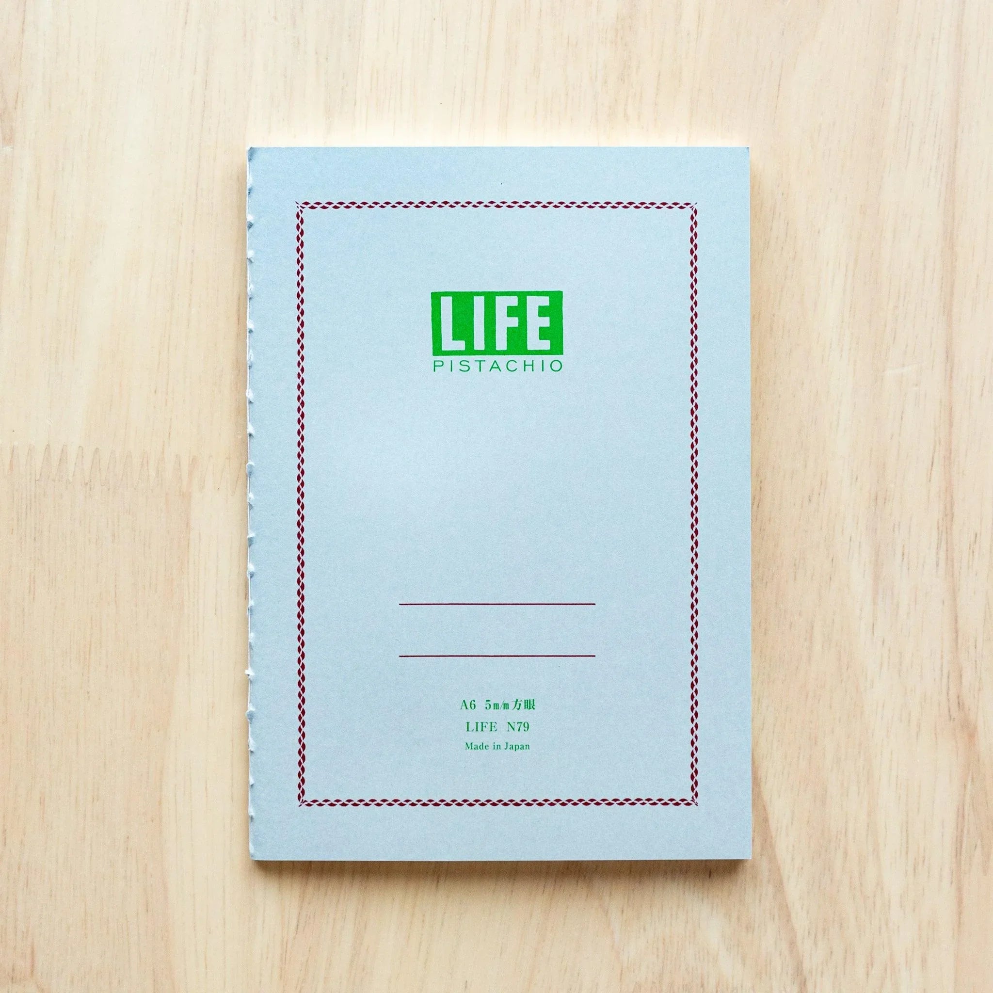 LIFE Pistachio notebook with green cover, angled overhead emphasizing soft green color tone and design